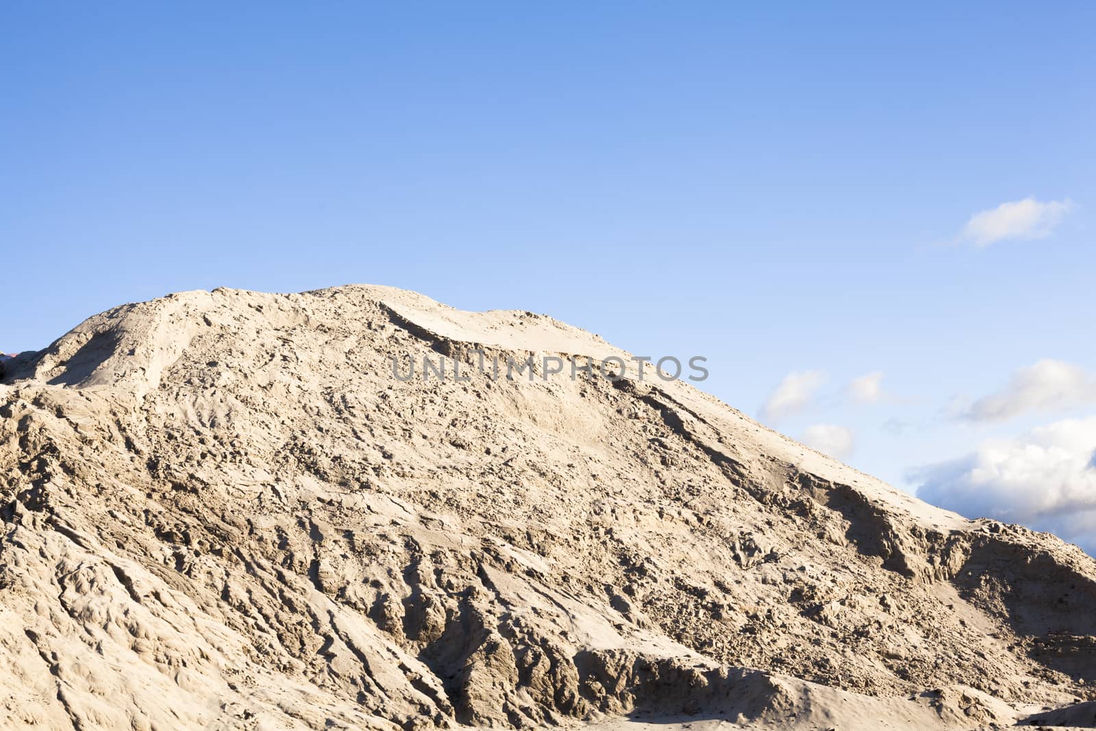 Pile of sand and blue sky over it.