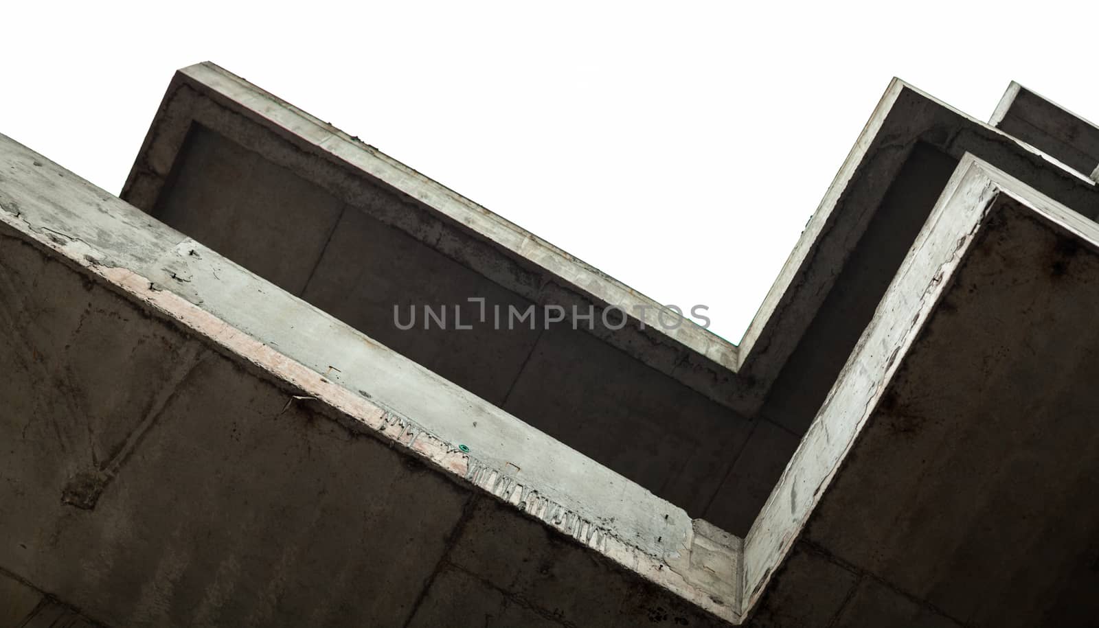 Concrete surfaces of the unfinished building against the white sky