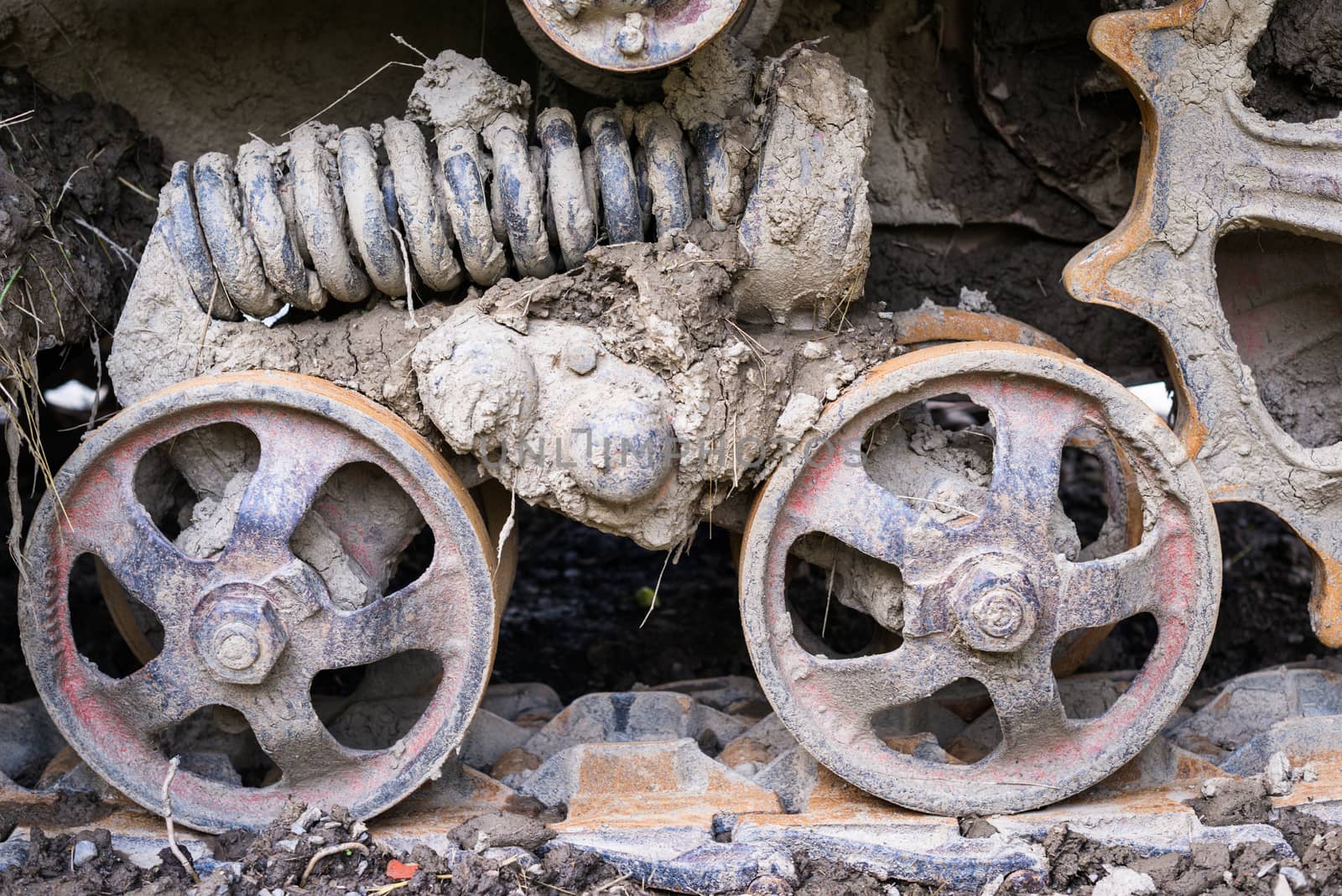 Road wheels of the continuous (caterpillar) tracks with mud. Close up.