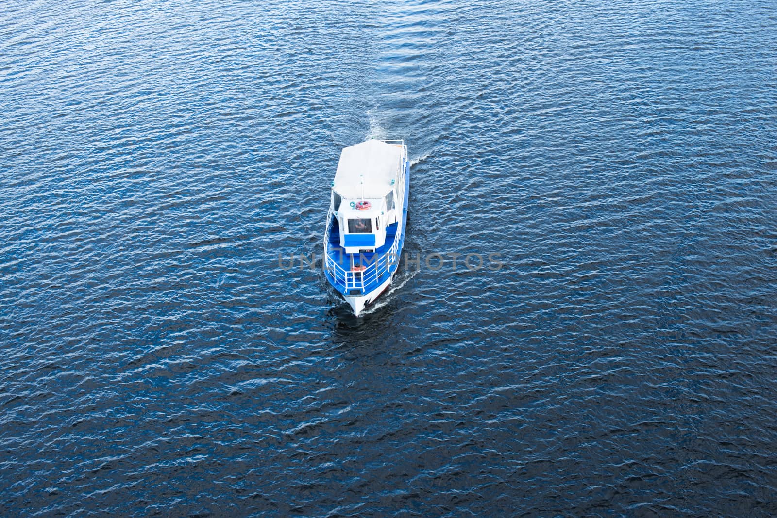 The boat floating in the blue Dnieper waters.