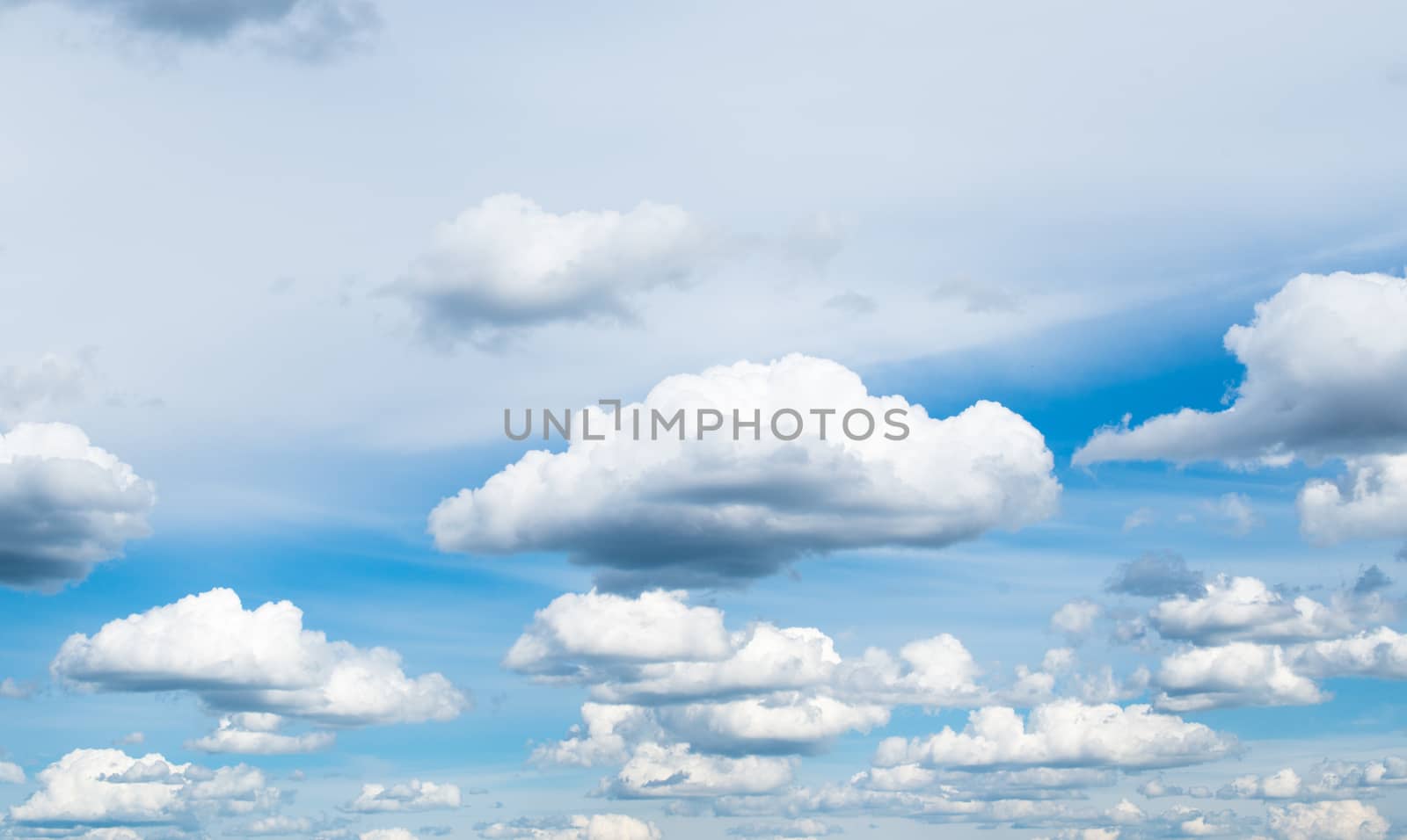 Cloudscape. The blue sky with white-grey clouds.