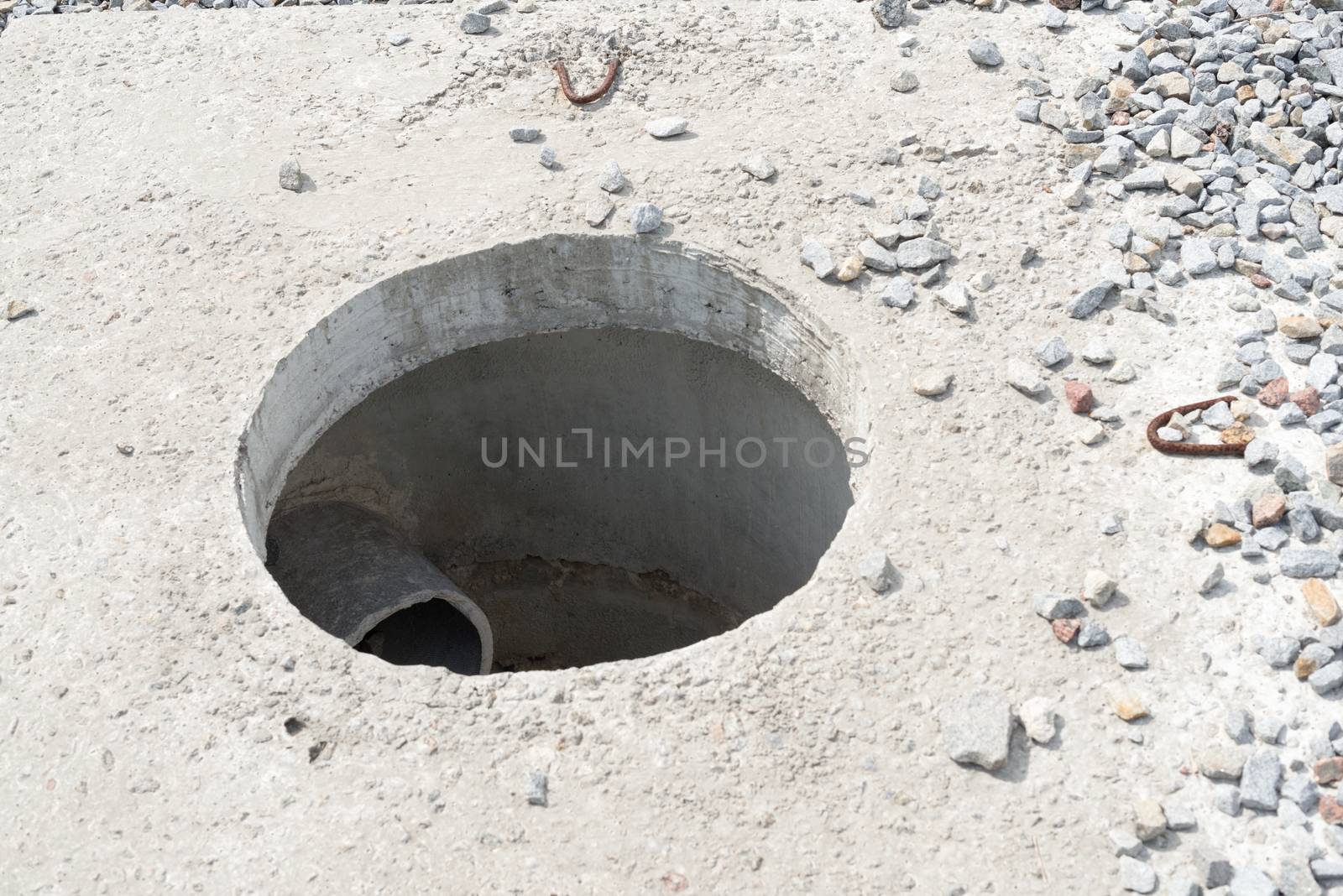 Manhole without cover in new concrete block.