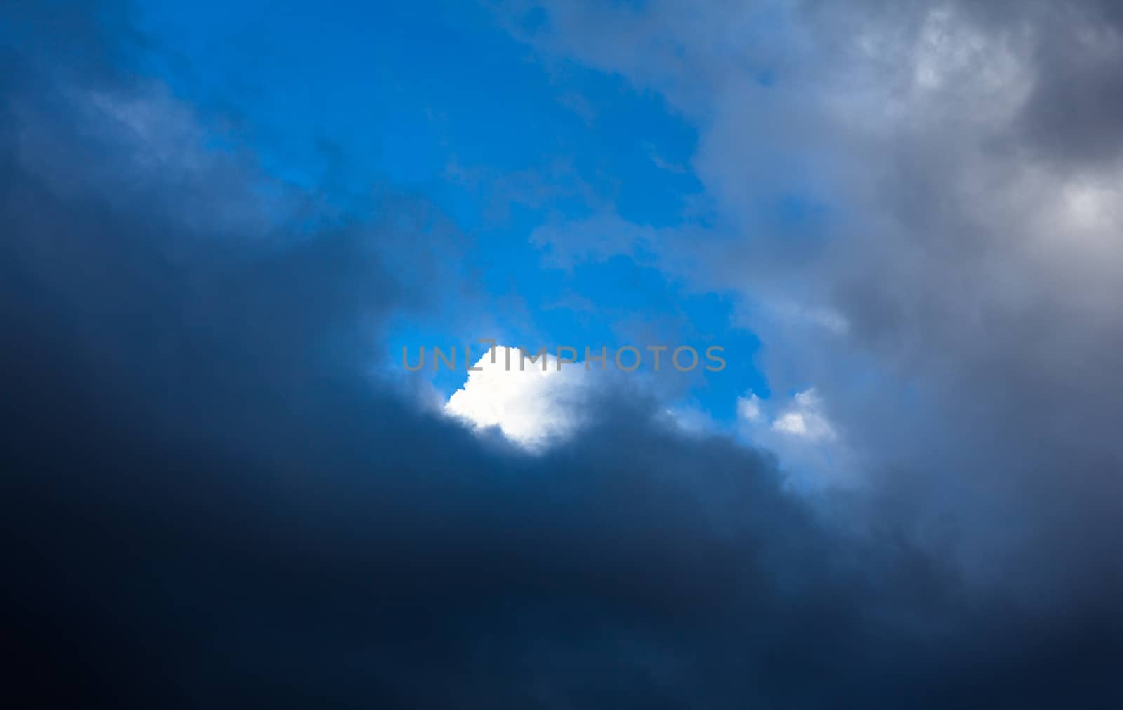 Cloudscape. White cloud behind the gray clouds by rootstocks