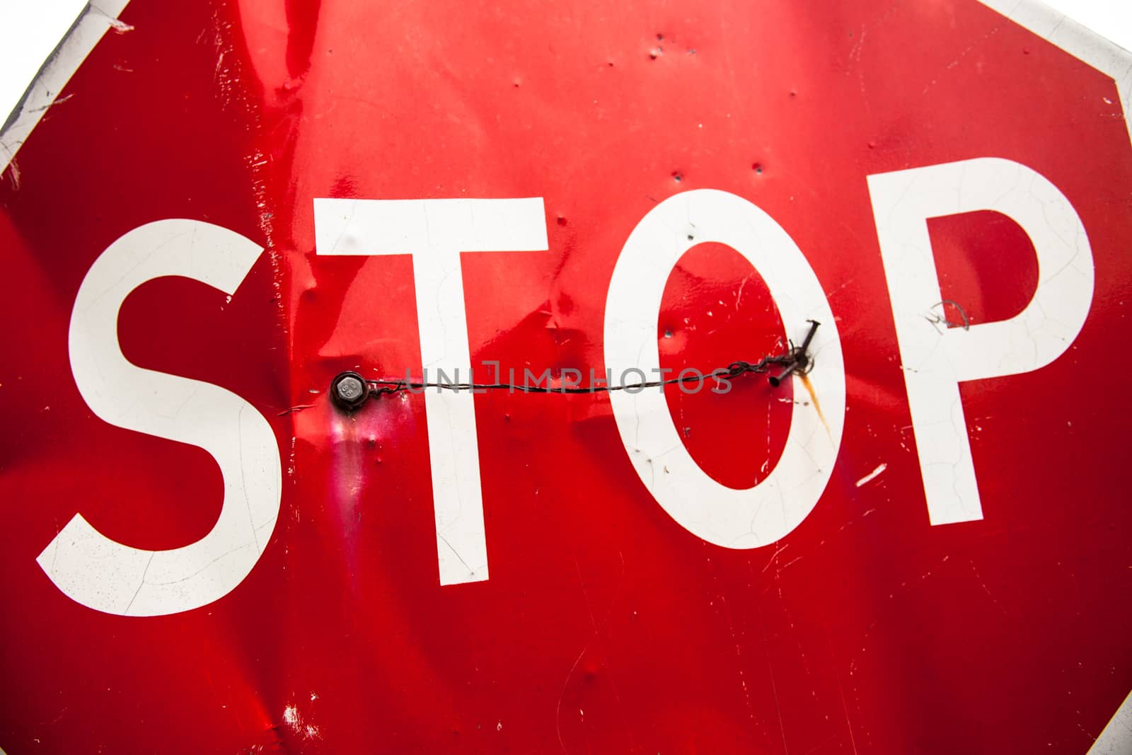 Stop sign with partly bent surface. Close up.