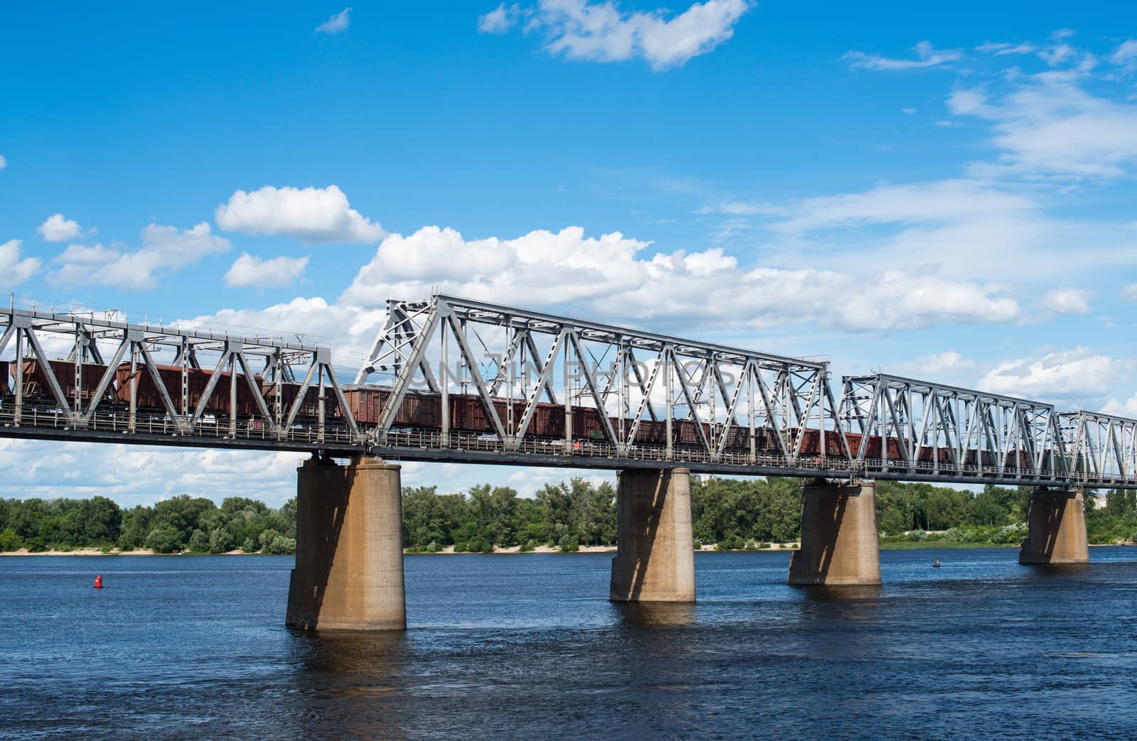 Railroad bridge in Kyiv across the Dnieper with freight train by rootstocks