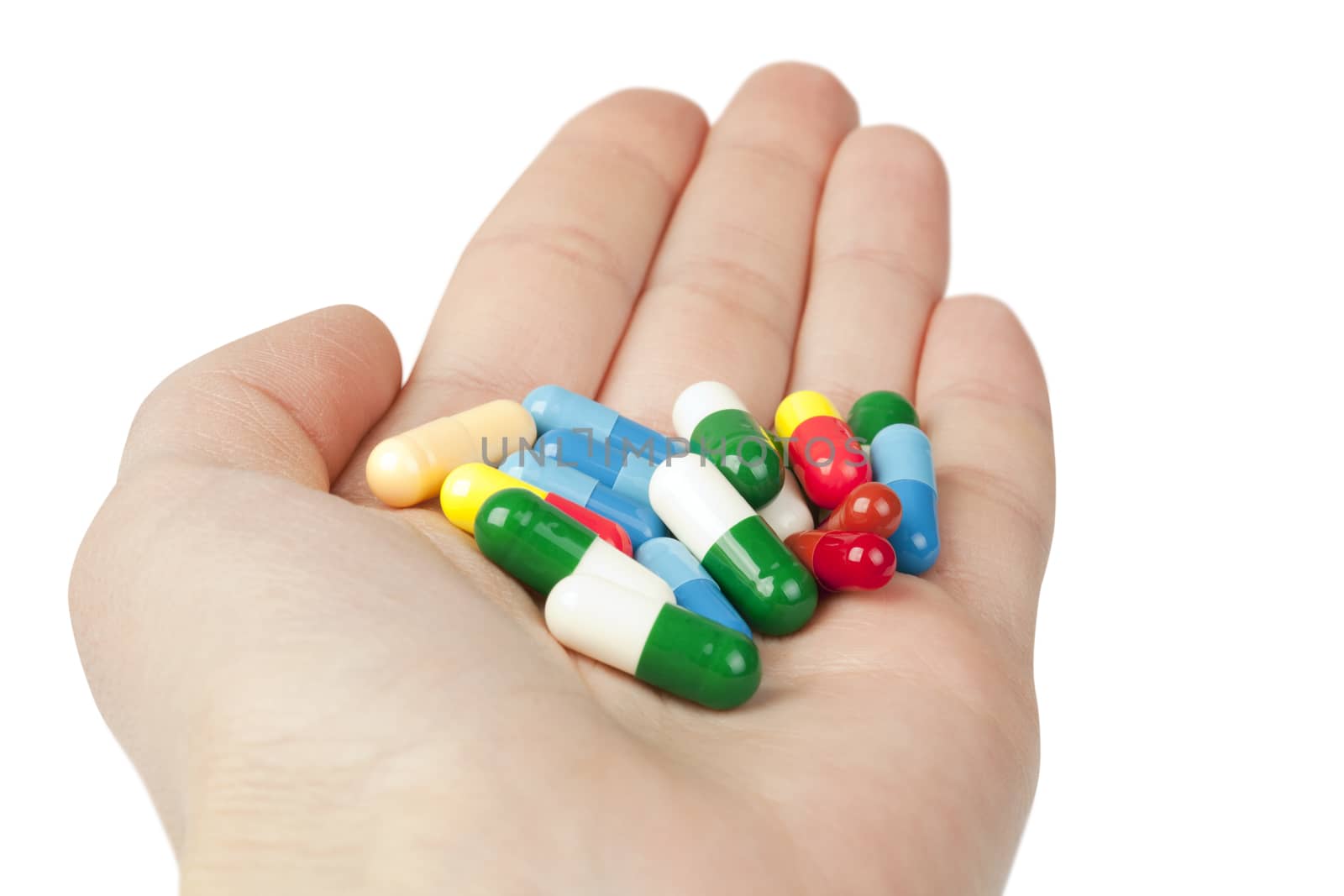 Many pills in the hand isolated on white. Medicine concept
