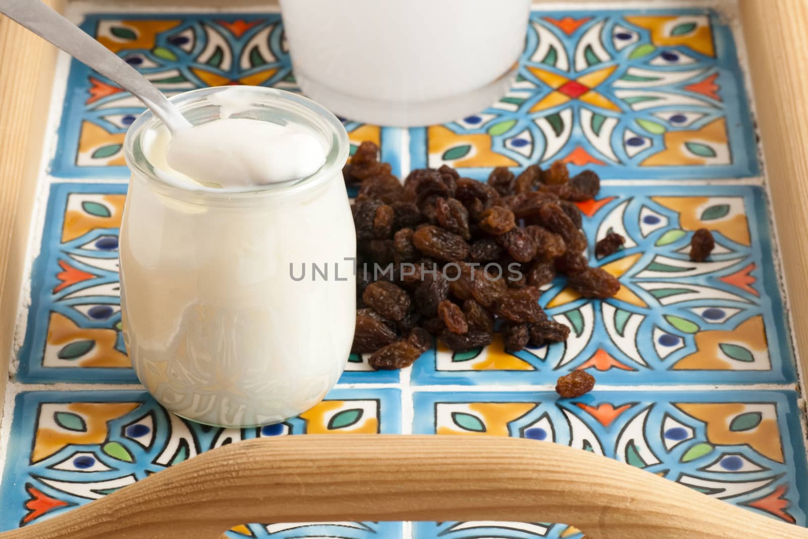 white yoghurt in a bowl with a small spoon and blueberries