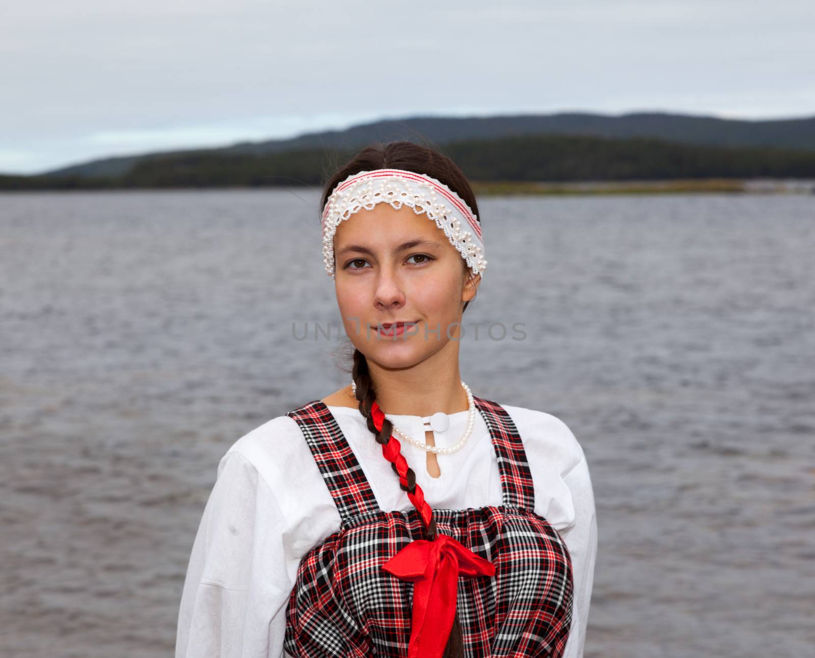 Young girl in national pomorian dress at the river shore Kovda