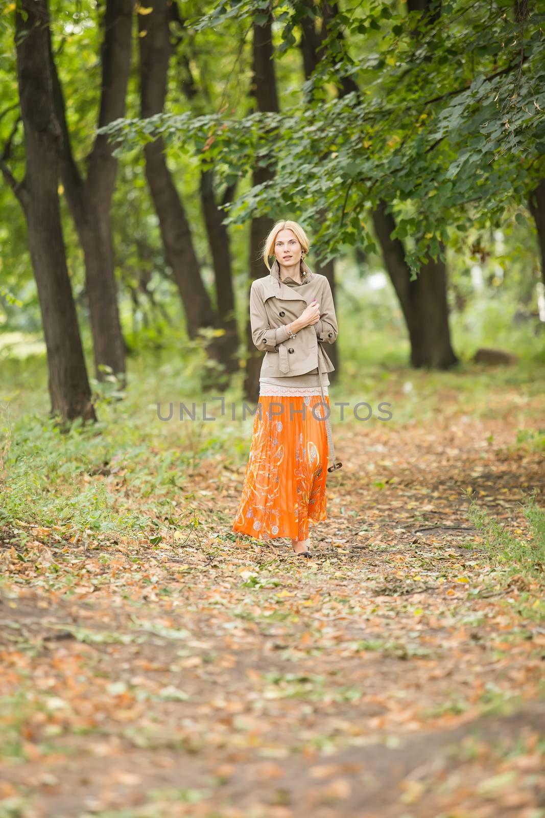 Young fashionable woman walking in spring park