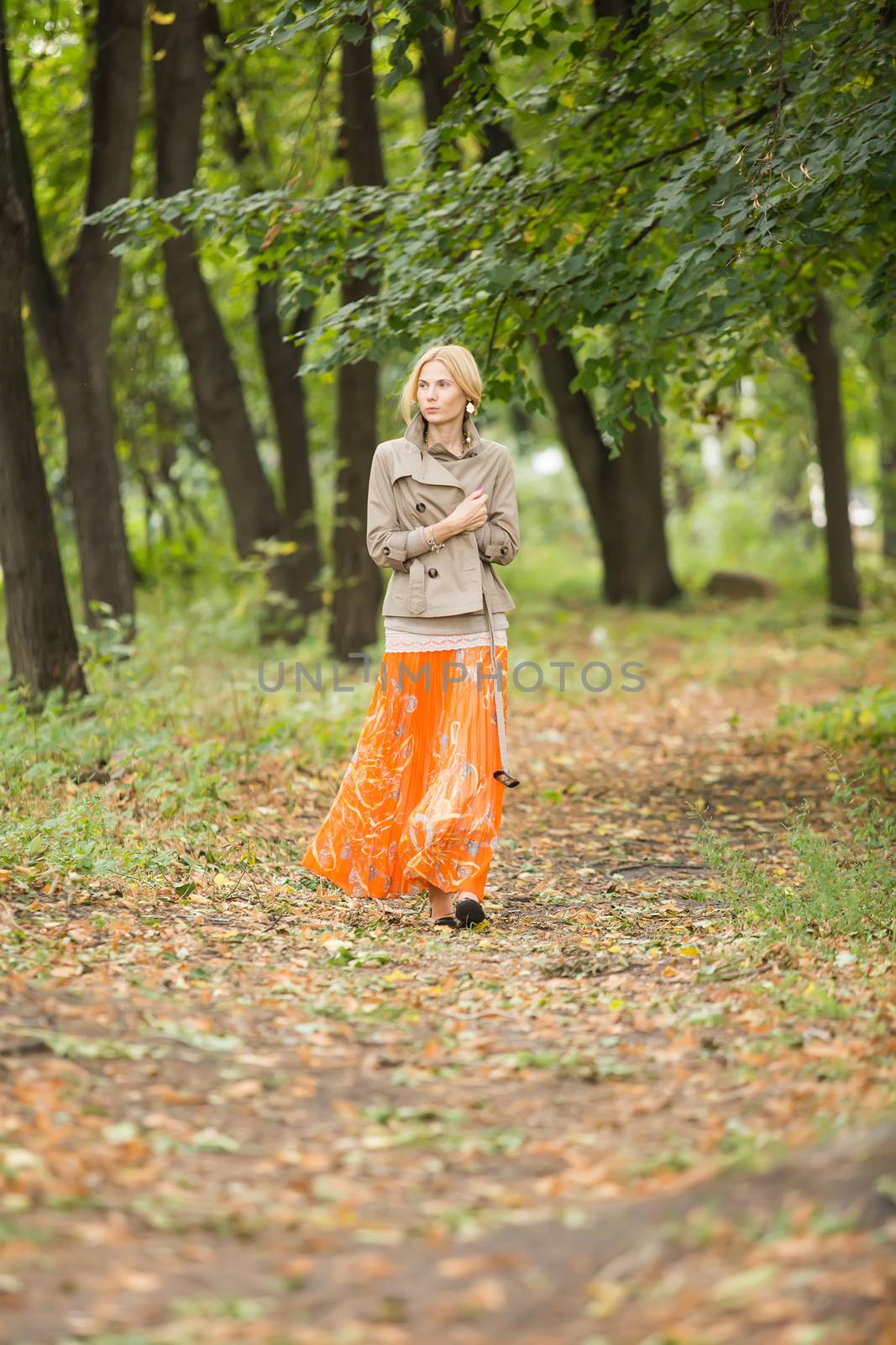 Young fashionable woman walking in spring park