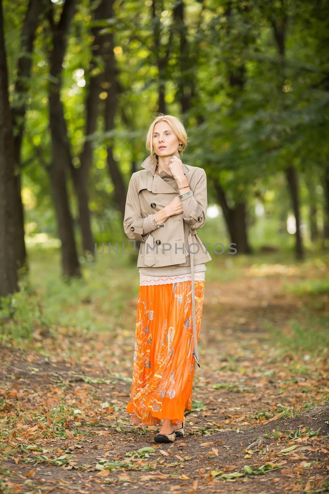 Young fashionable woman walking in spring park