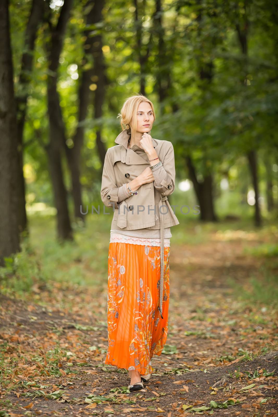 Young fashionable woman walking in spring park