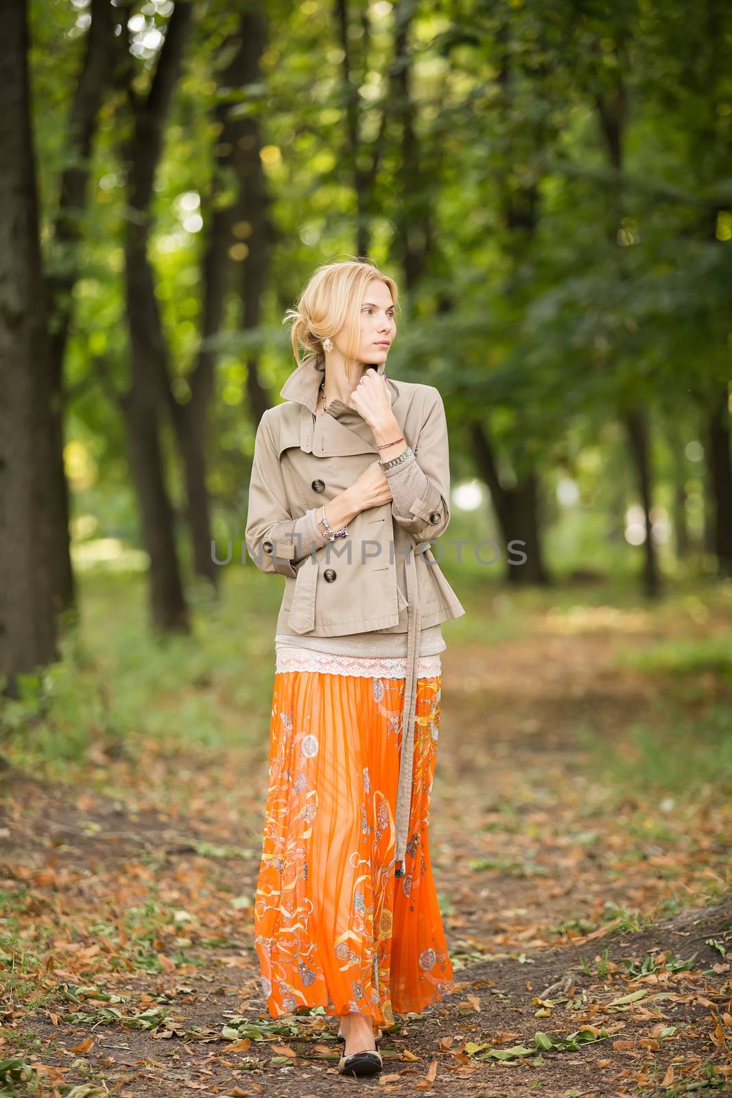 Young fashionable woman walking in spring park