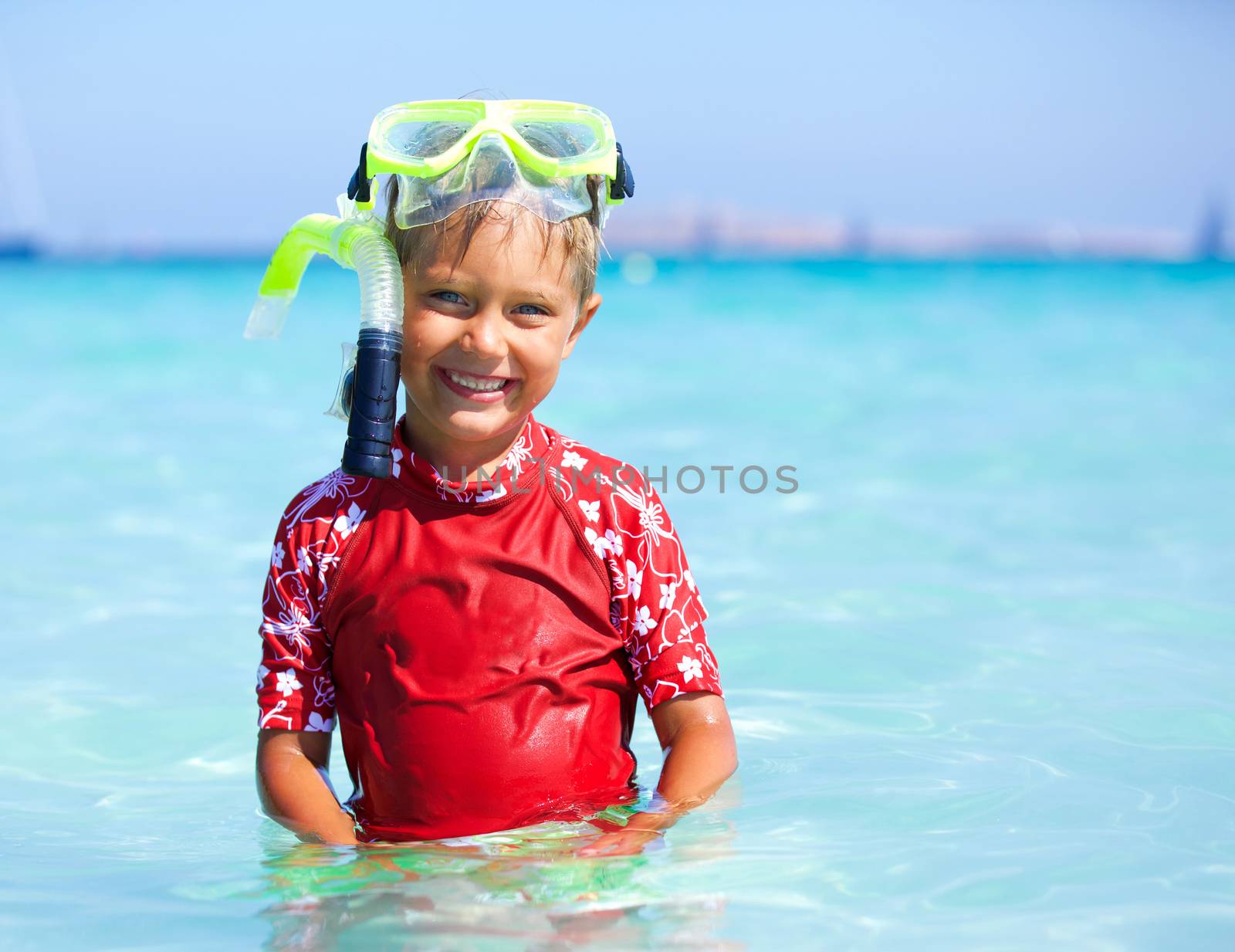 Portrait of happy cute boy wearing snorkeling mask ready to dive in the sea