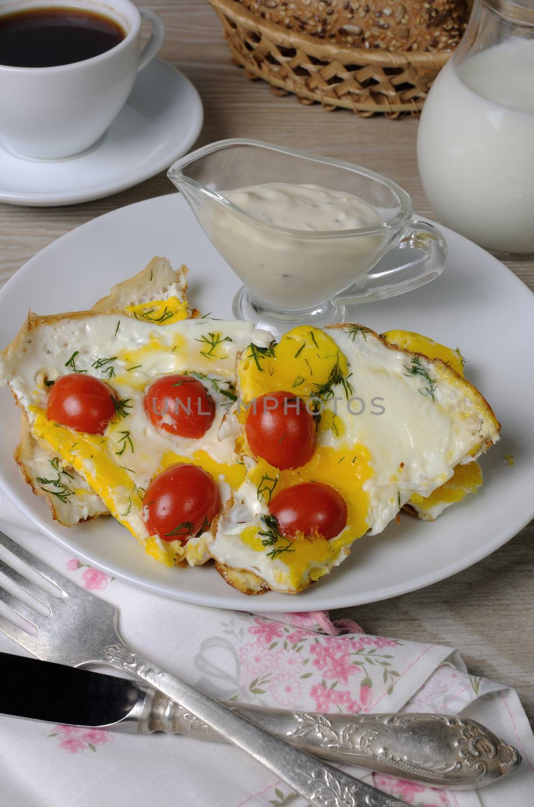 Scrambled eggs with cherry tomatoes, sliced baguette and a cup of coffee