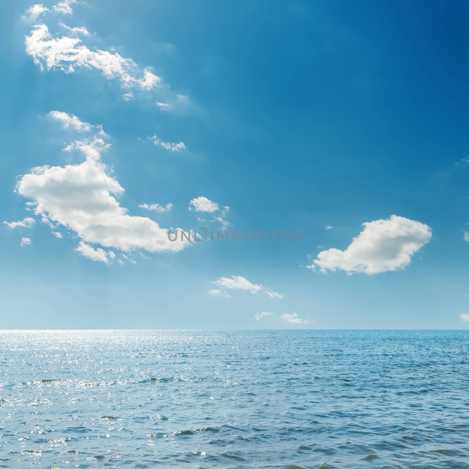 clouds in blue sky over sea by mycola