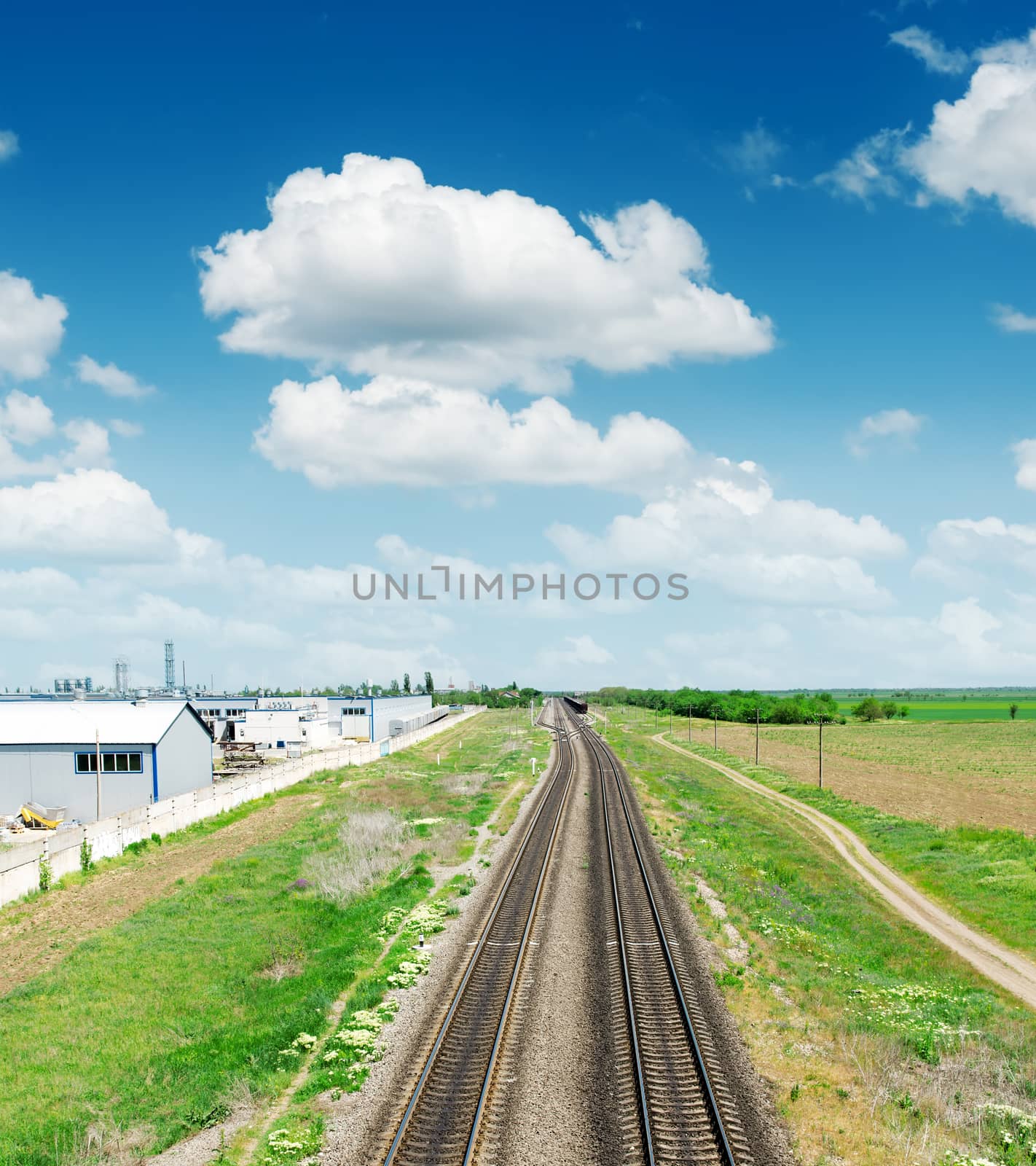 two railway to horizon in green landscape under blue sky with cl by mycola