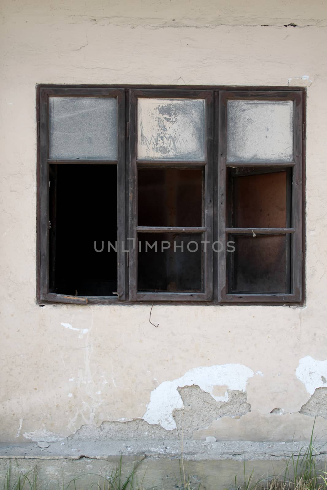 Old shabby wall with old broken wooden window