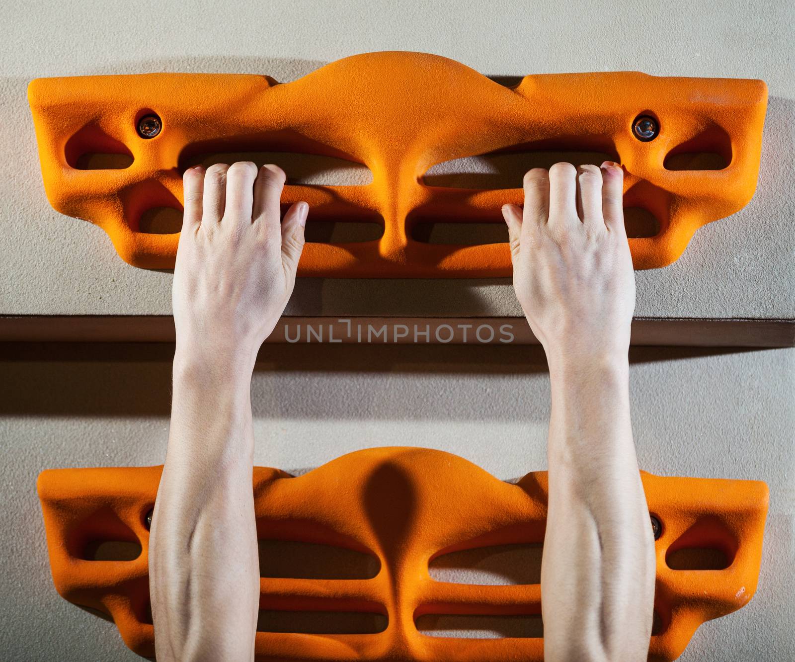 Cropped view of rock climber performing pull-ups on fingerboard