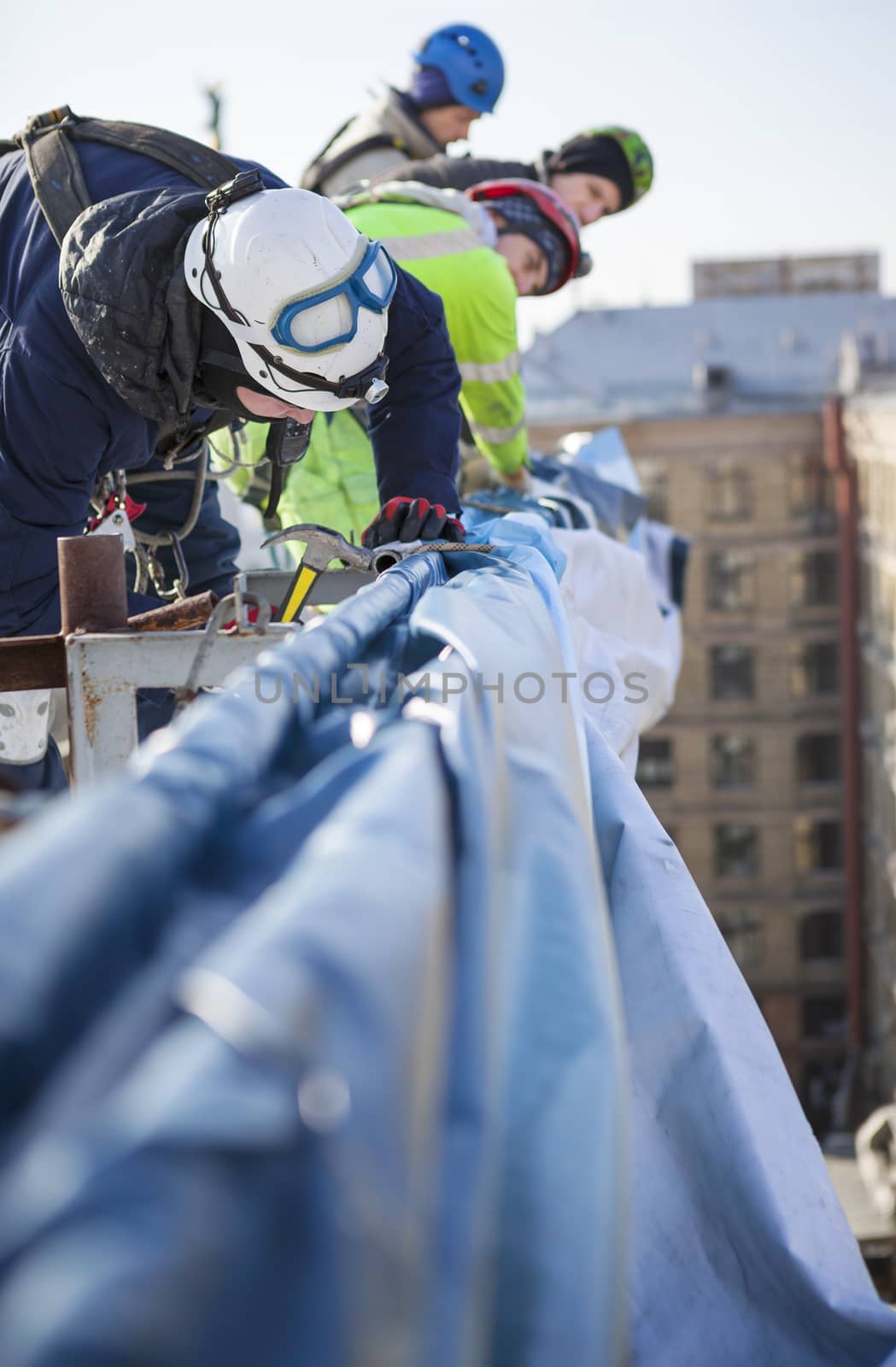 Industrial climbers working on roof of building by photobac