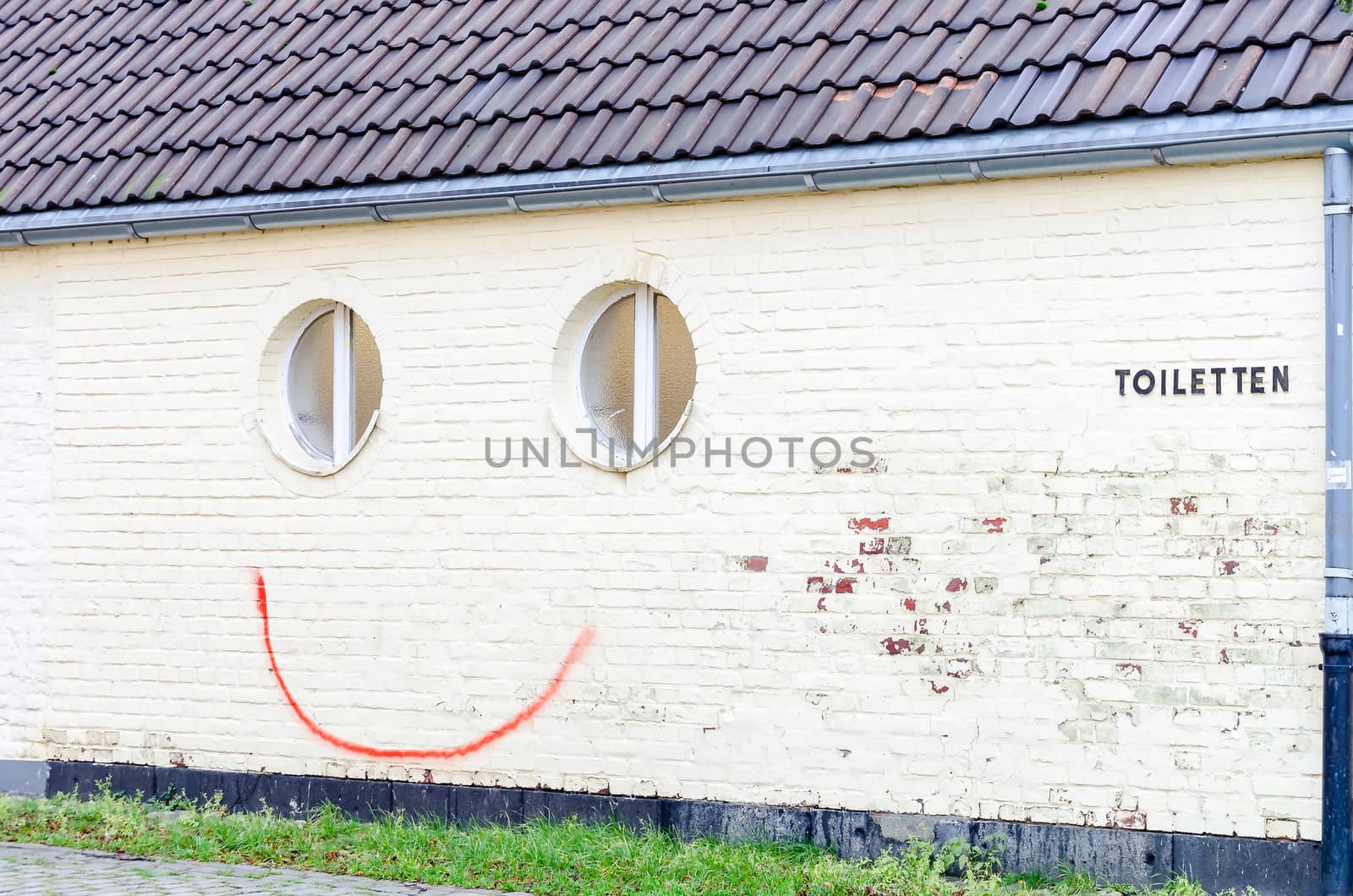 Fun, spray painted smiley on a house wall.