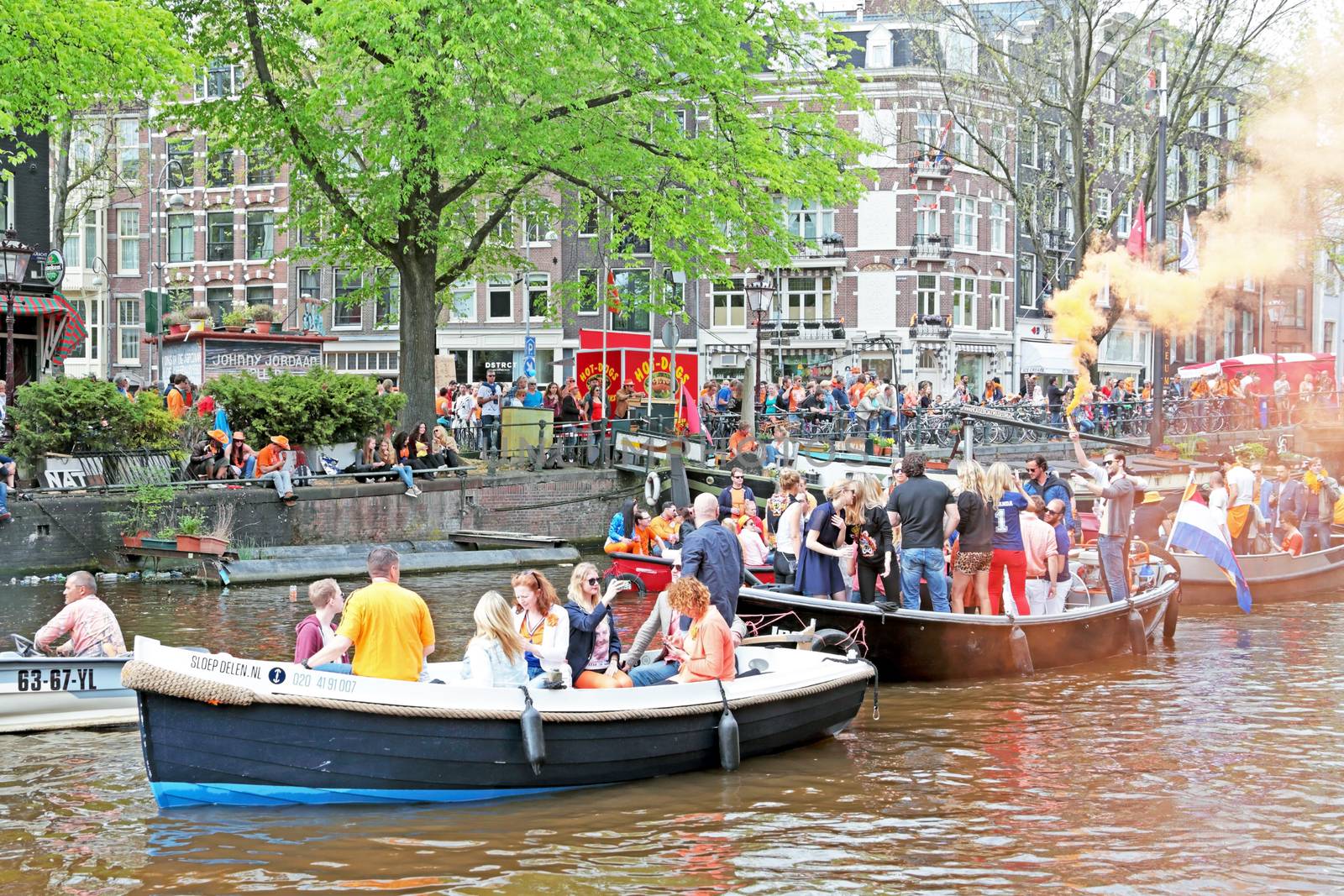 AMSTERDAM - APRIL 26: Canals of Amsterdam full of people in orange on boats during the celebration of kings day on April 26, 2014 in Amsterdam, The Netherlands