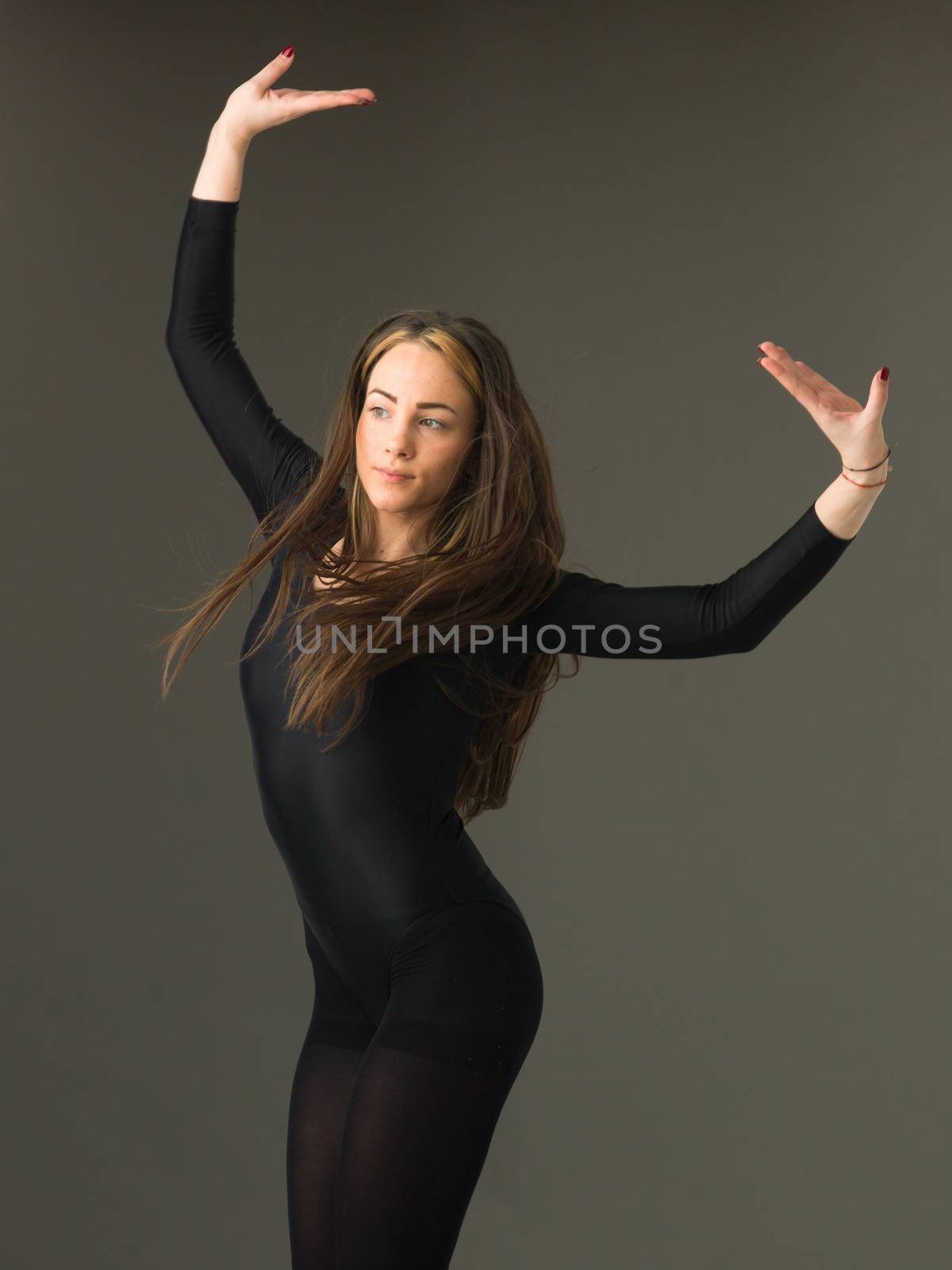 portrait of beautiful jumping ballerina on grey background