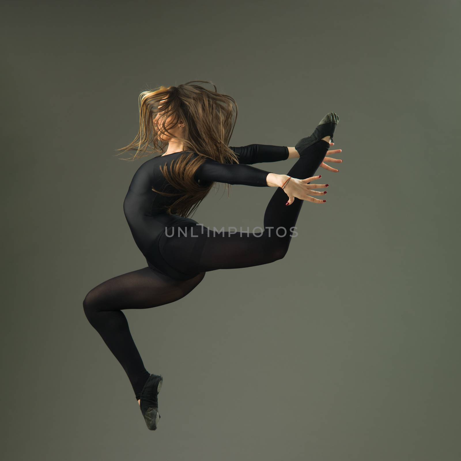female dancer jumping against grey background