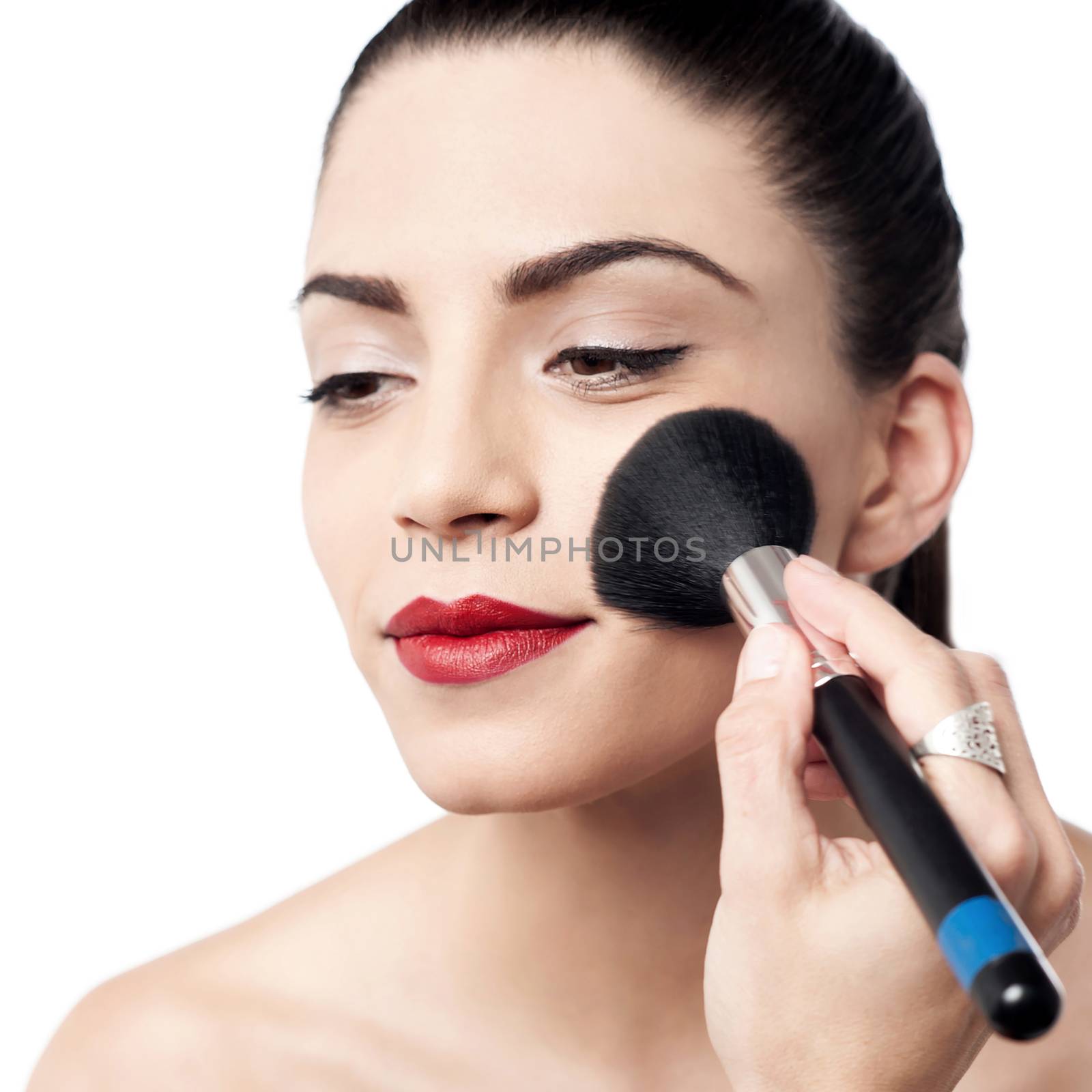 Attractive woman applying foundation by stockyimages