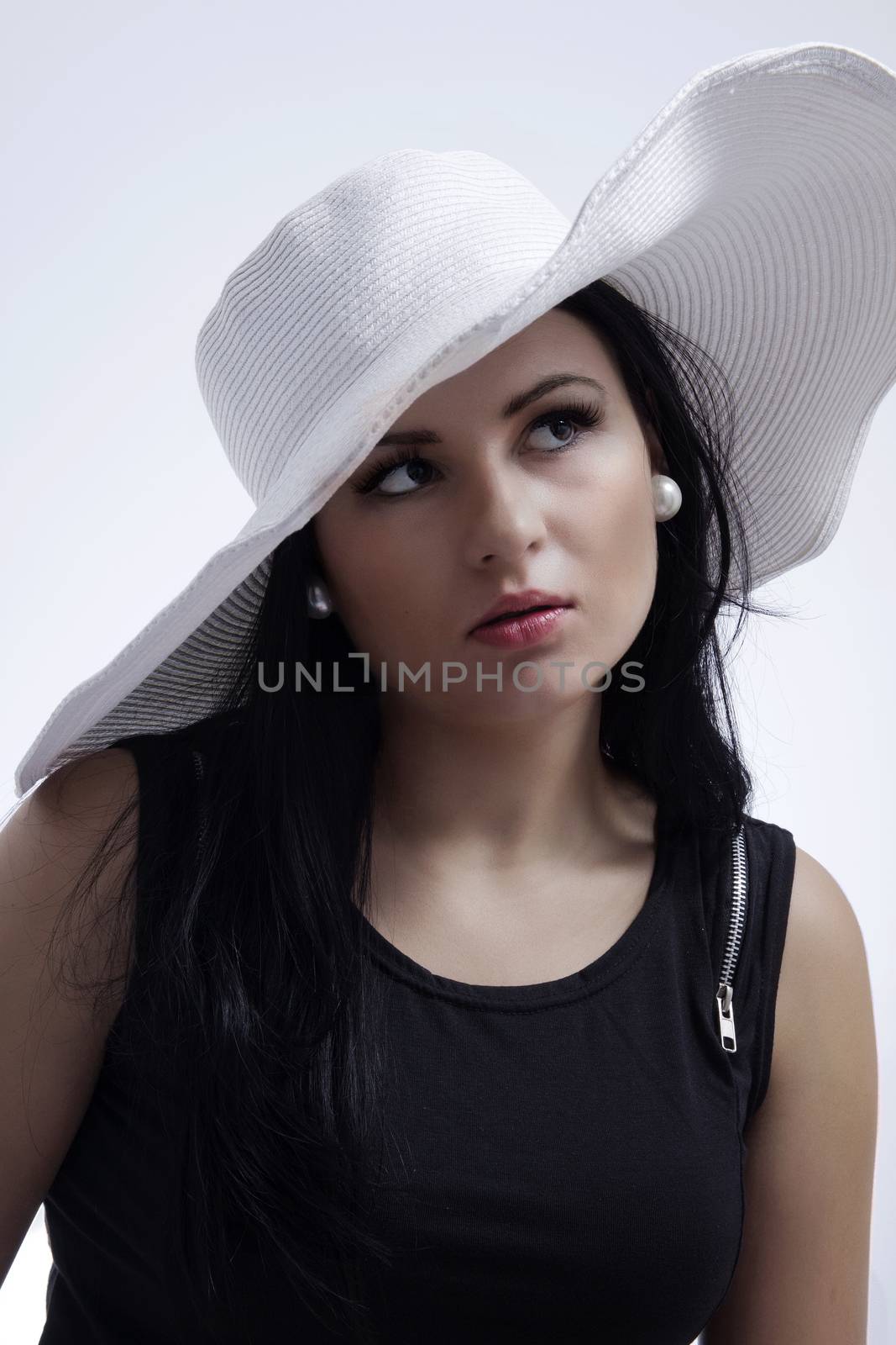 Young long-haired woman in a big white hat in the French style