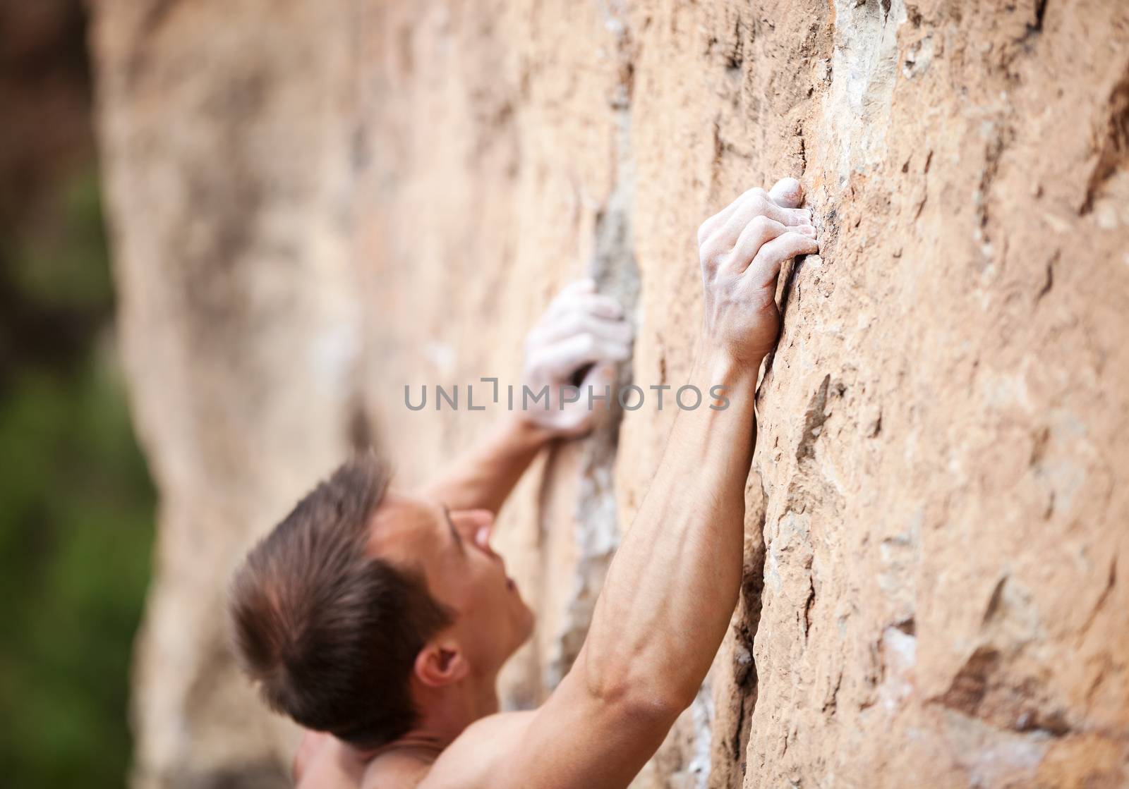 Cropped view of male rock climber on cliff by photobac
