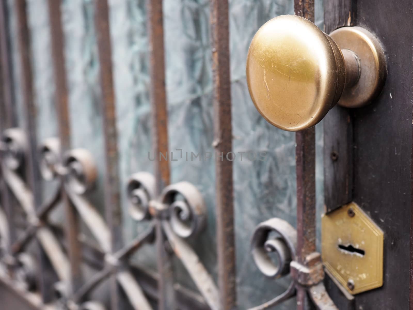 Ancient door gate with brass knob by rigamondis