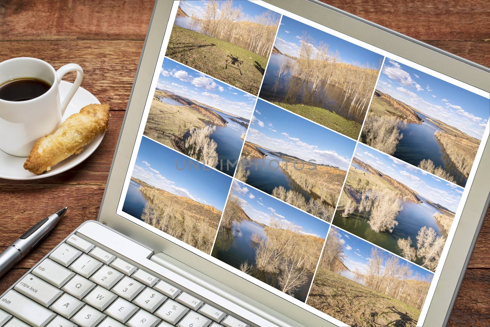 Reviewing and editing a sequence of time lapse aerial pictures on a laptop - lake landscape in Colorado with a drone shadow.