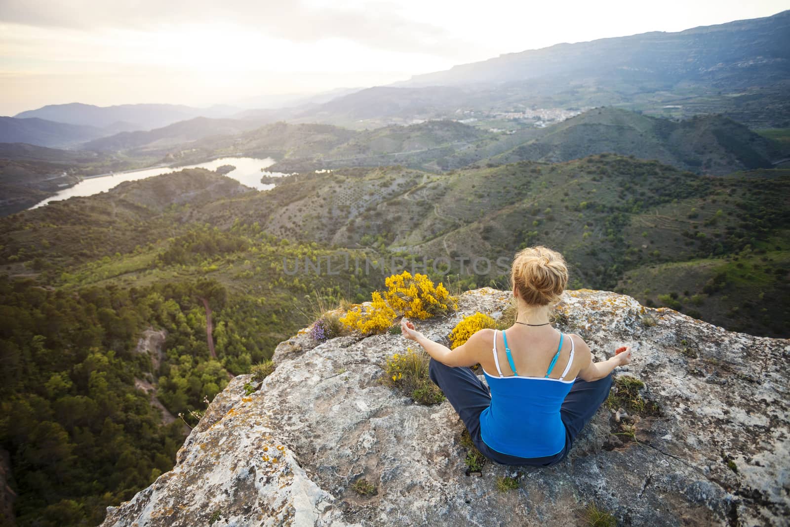Woman sitting on a rock and enjoying valley view by photobac
