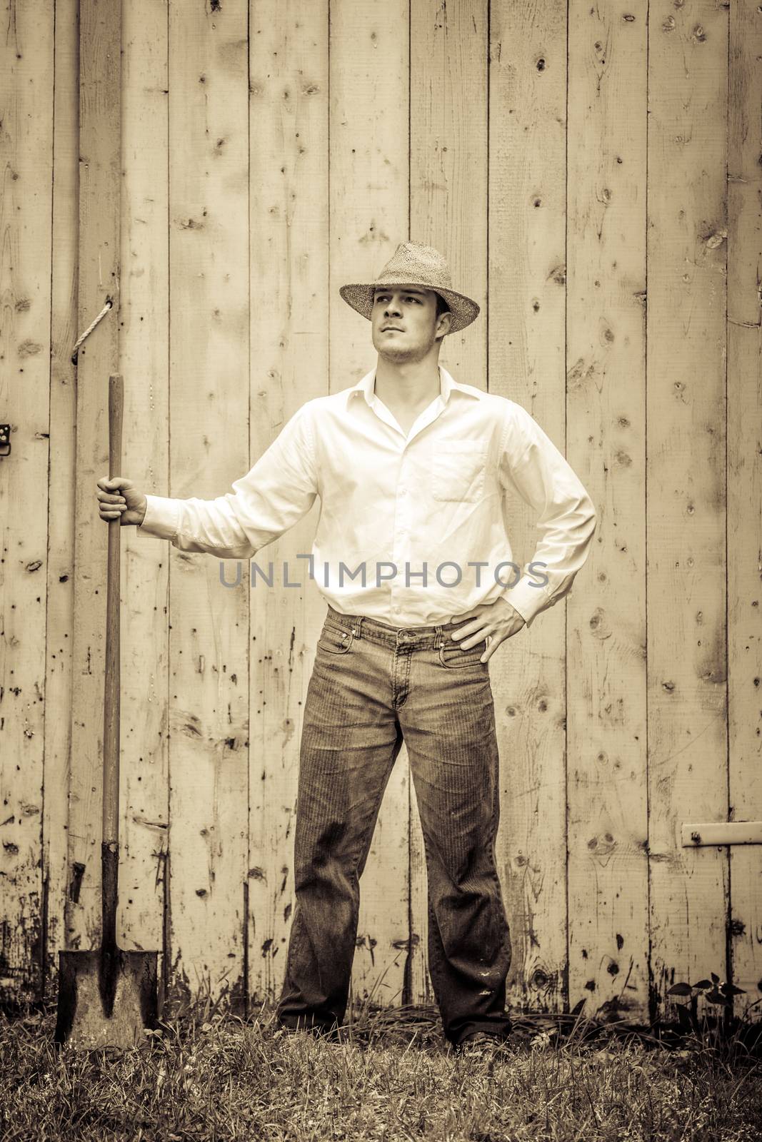 Young Proud Farmer standing up in front of Barn