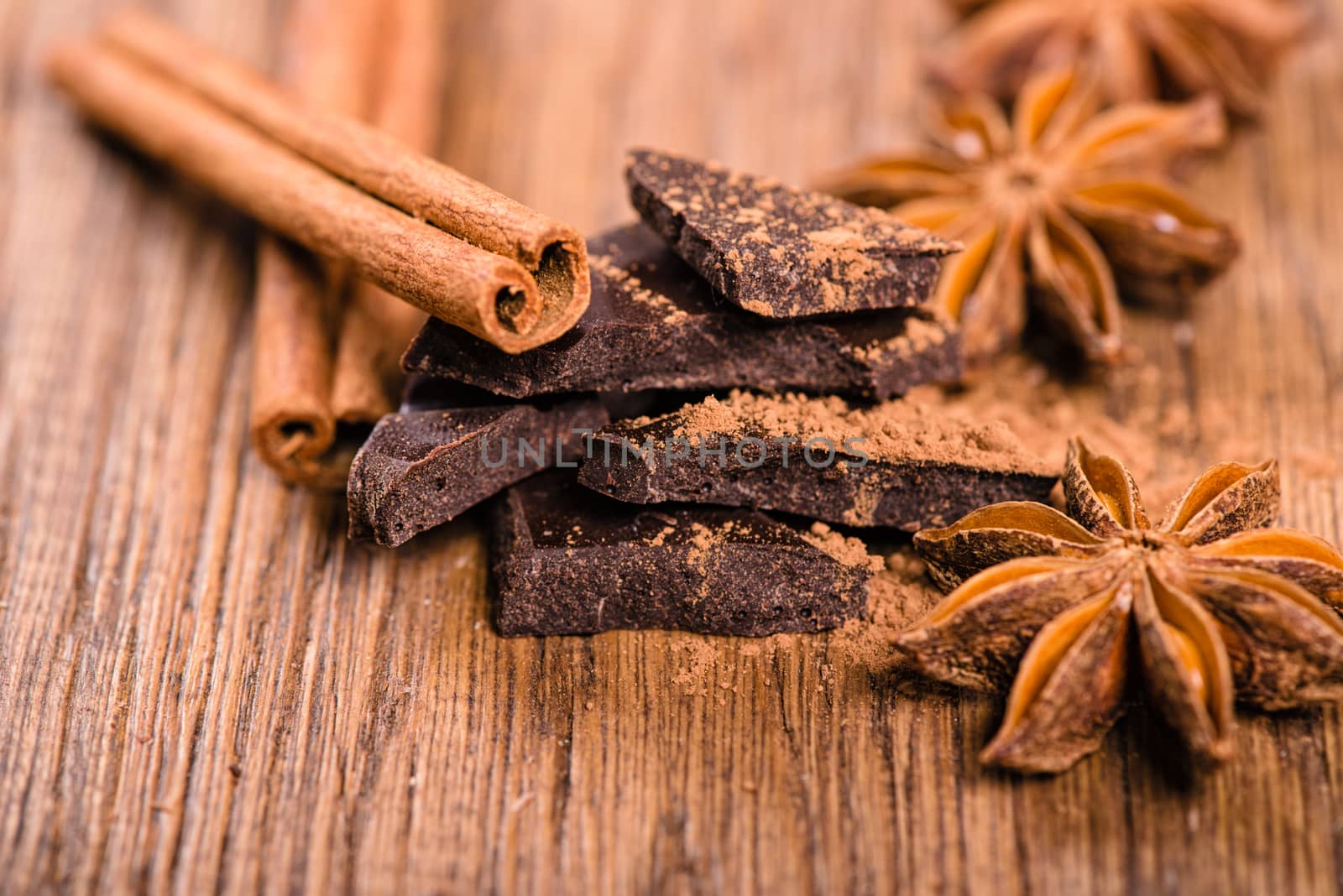 chocolate pieces, star anise and cinnamon sticks close up