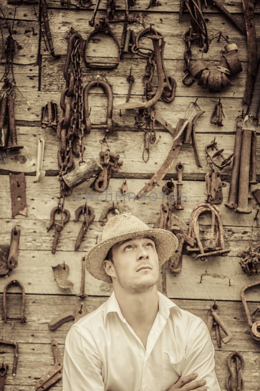 Farmer Portrait in front of a Wall Full with Old Rusty Tools