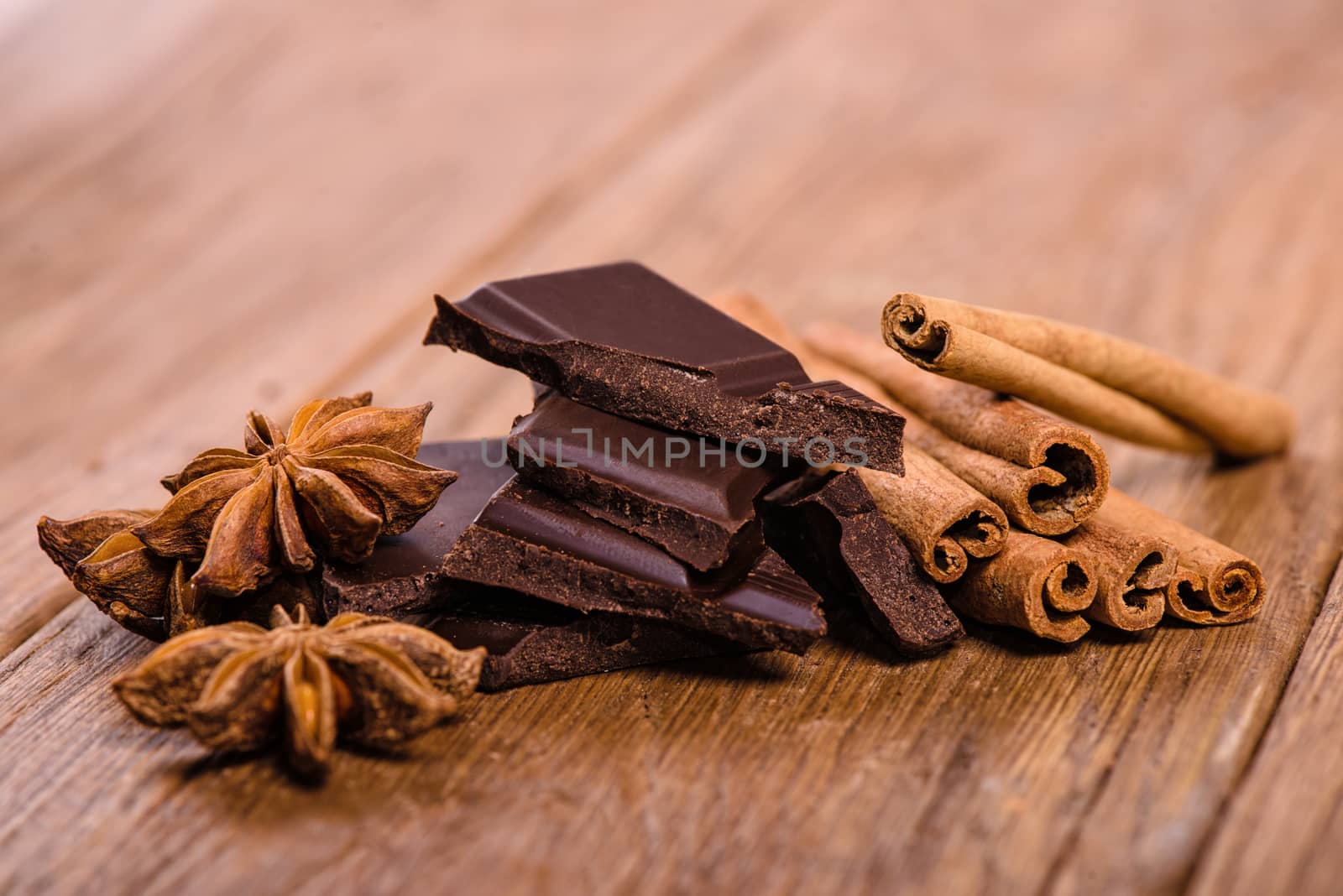 chocolate pieces, star anise and cinnamon sticks close up