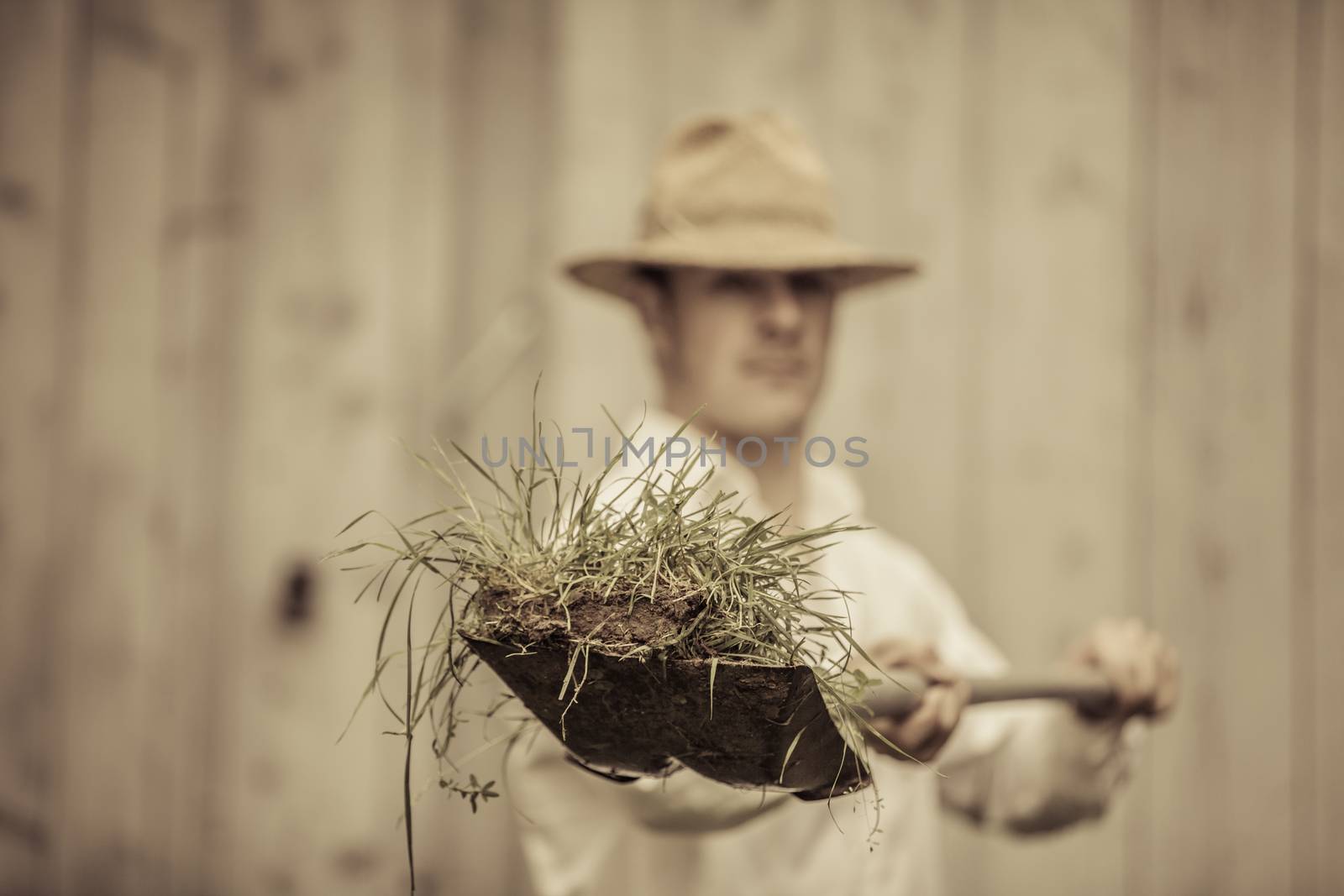 Farmer with a Shovel Full of Grass by aetb