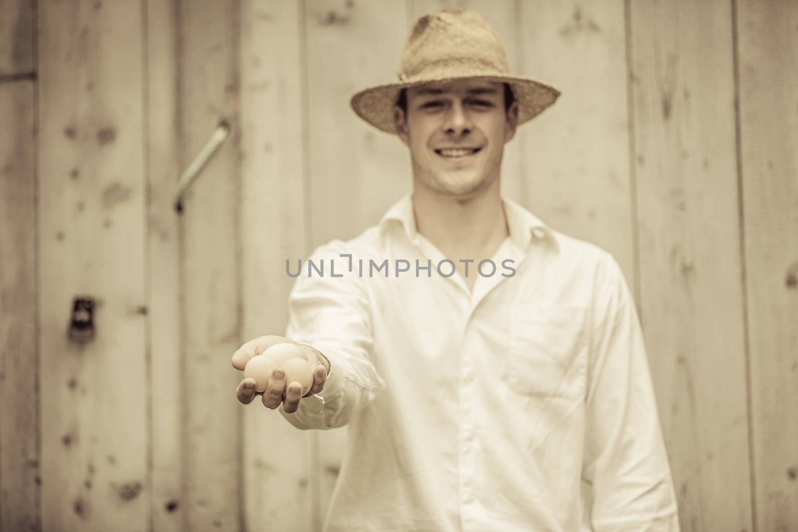 Closeup of Farmer Holding Eggs in front of a Farm