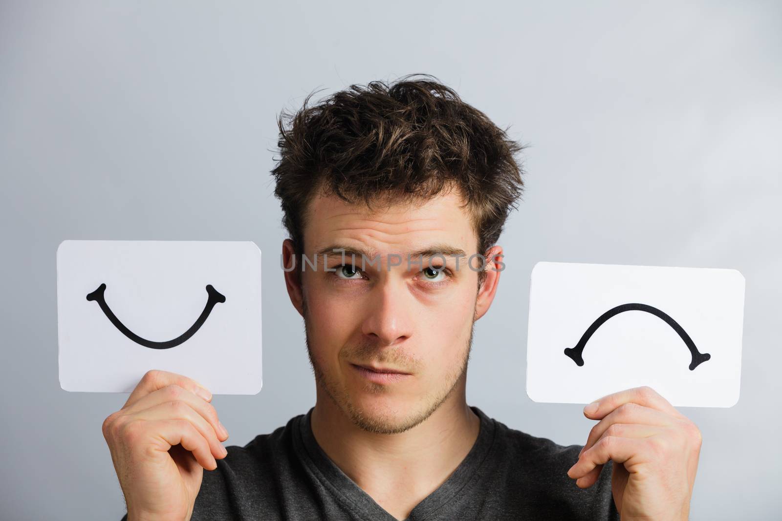 Portrait of a Questioning Man Holding Happy and Unhappy Survey Mood Board