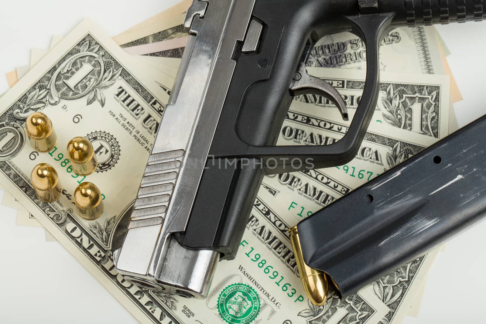 detail of gun with bullet on US dollar banknotes, crime or corruption concept
