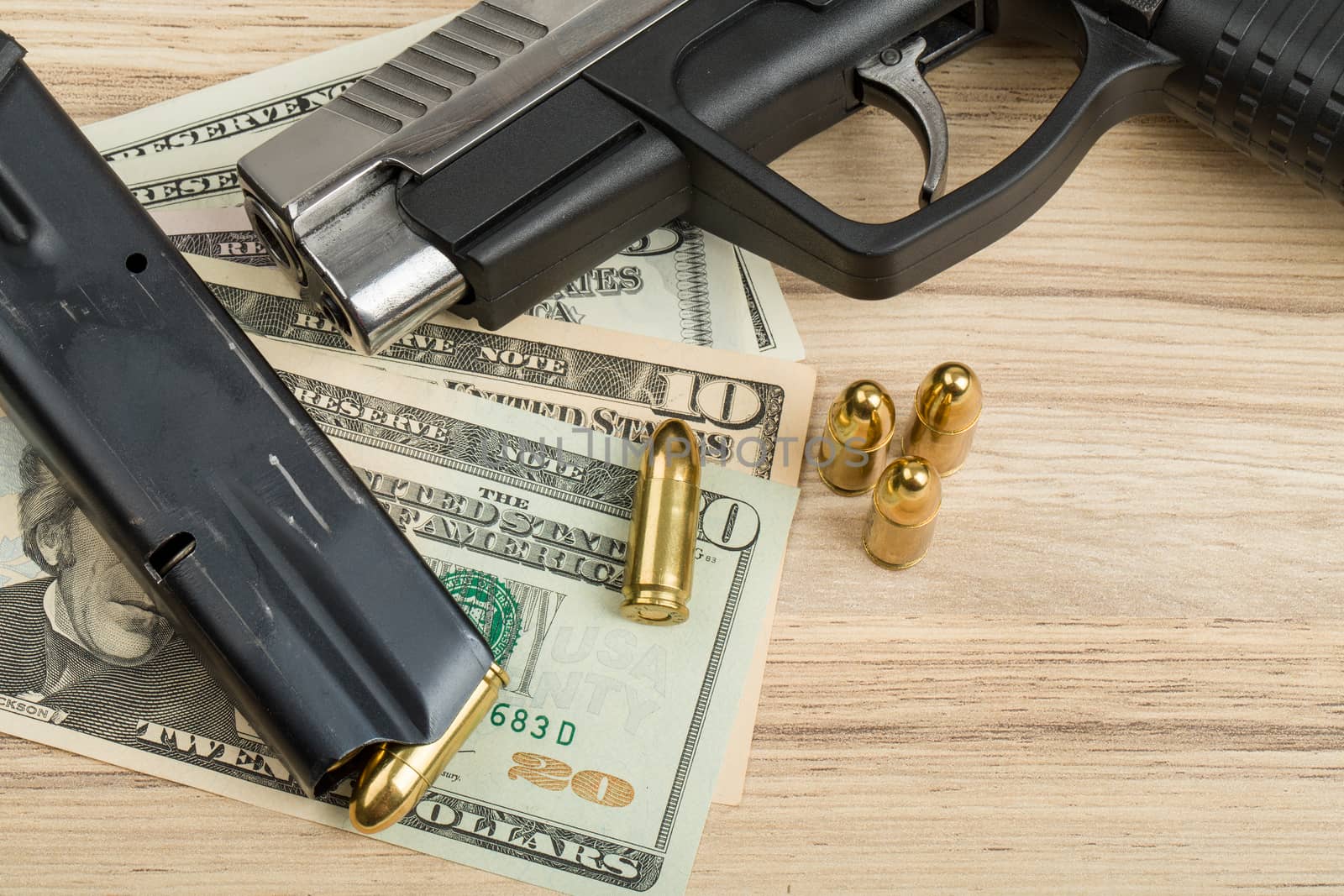 detail of gun with bullet on US dollar banknotes, crime or corruption concept
