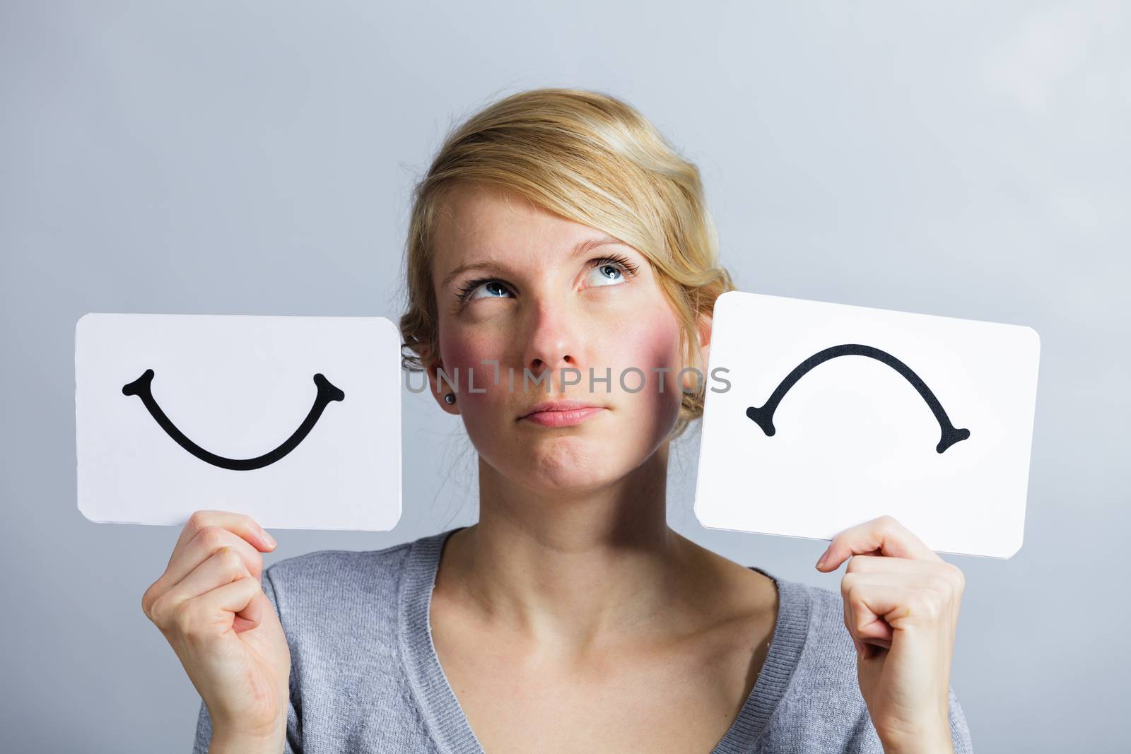 Portrait of a Questioning Woman Holding Happy and Unhappy Survey Mood Board