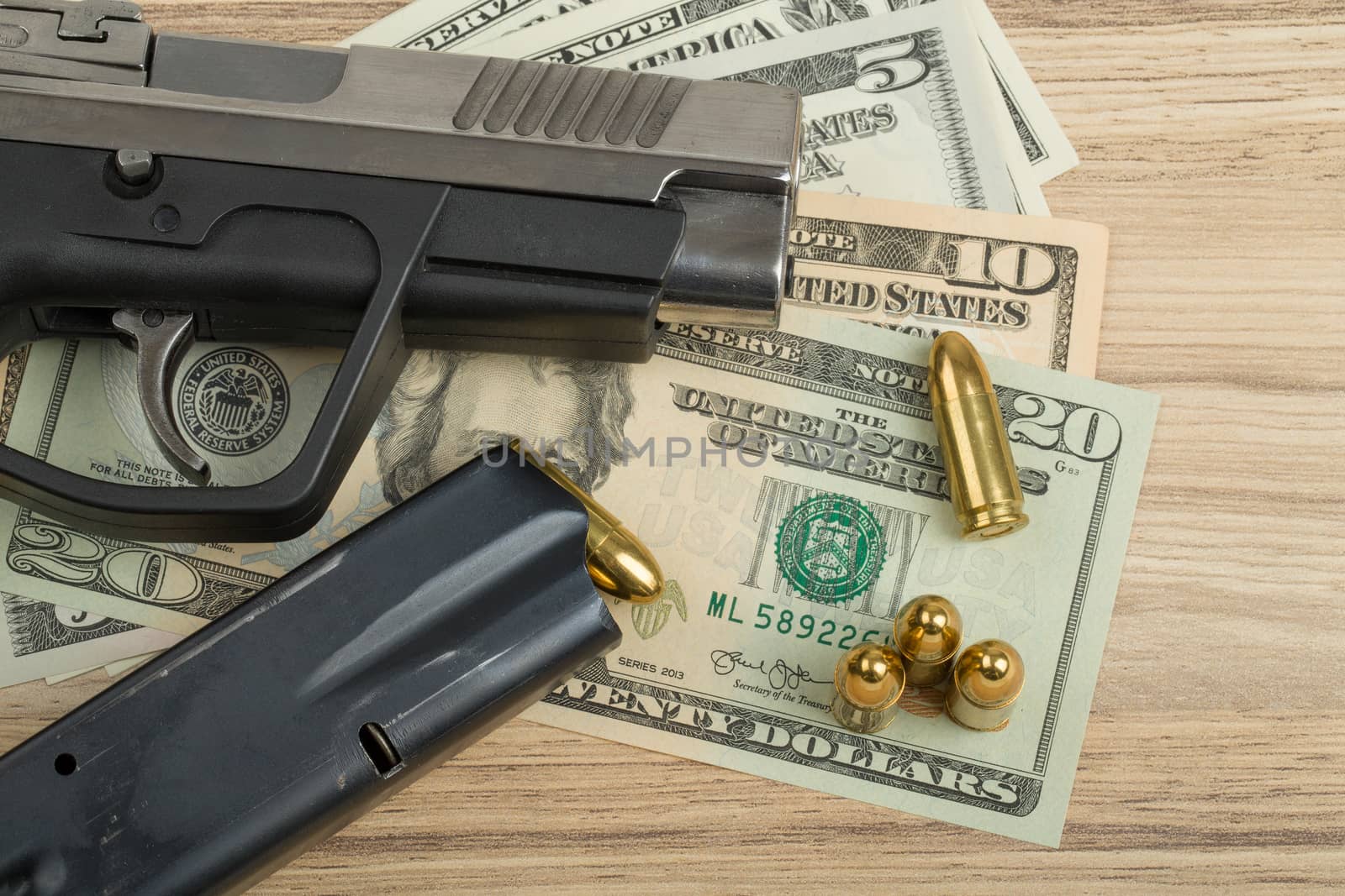 detail of gun with bullet on US dollar banknotes, crime or corruption concept