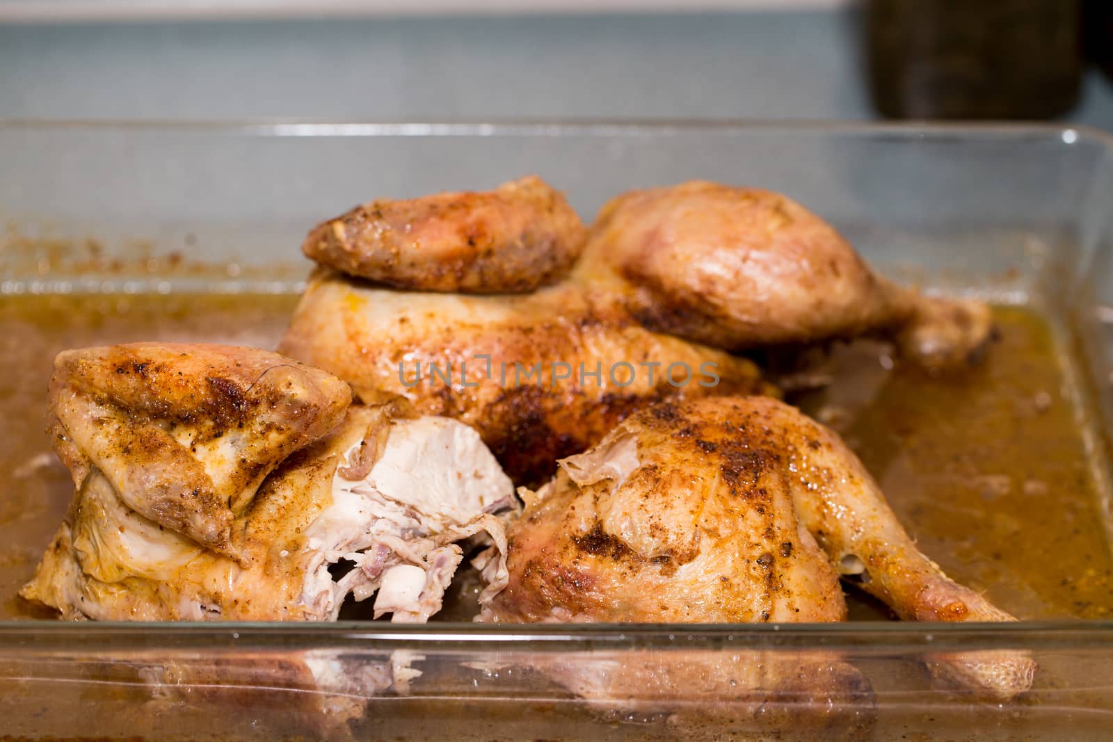Roasted pieces of fresh chicken on pan with shallow focus