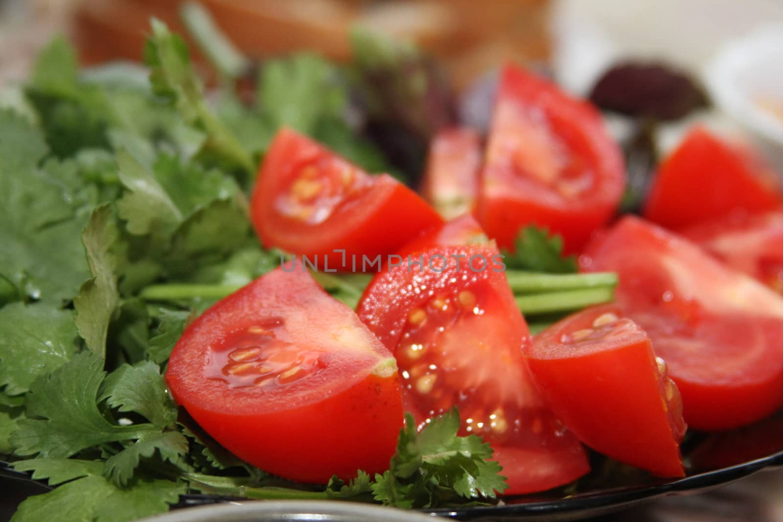 Bright juicy red tomatoes and cilantro leaves, parsley by mcherevan