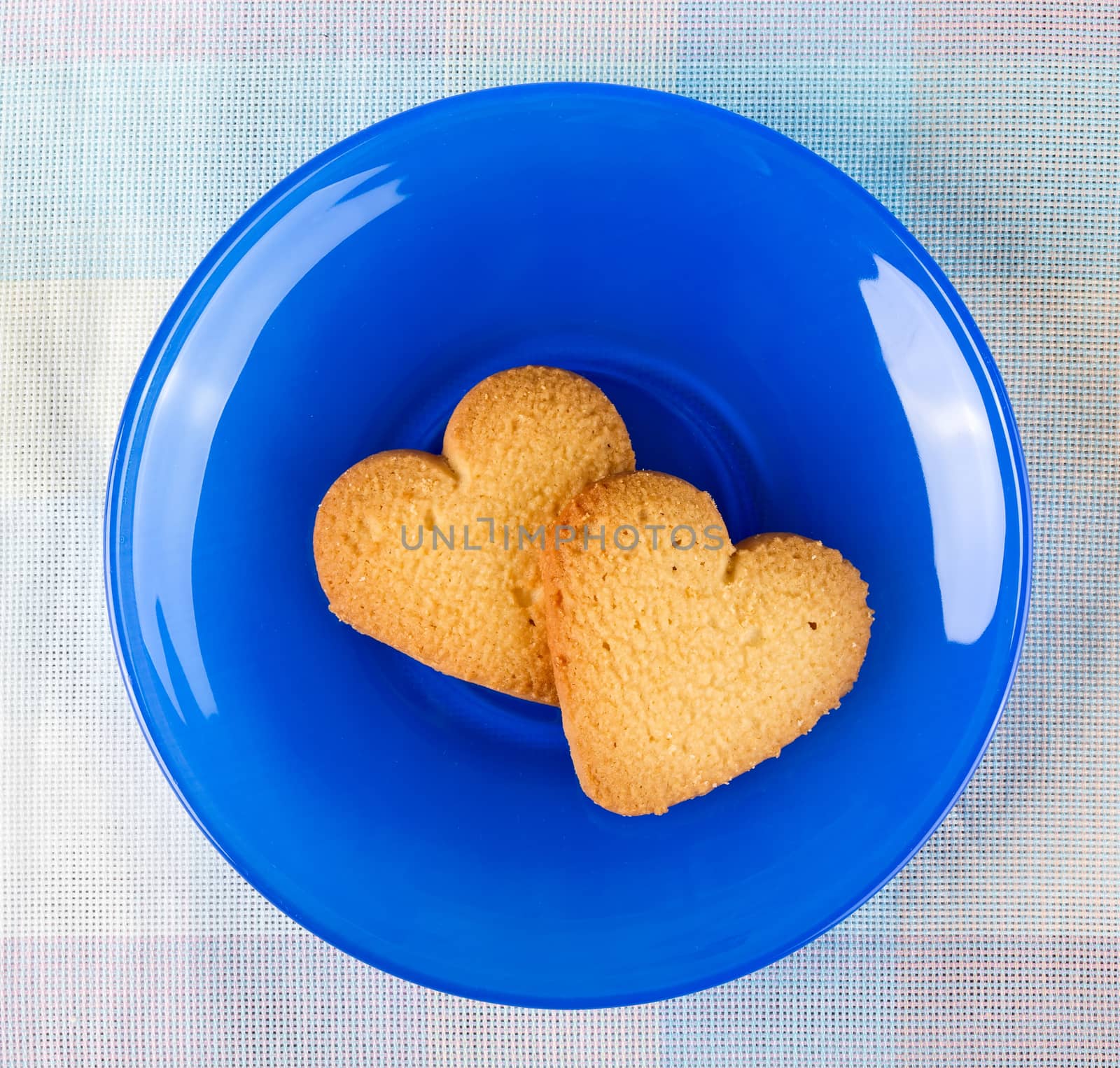 Two sweet heart cookies on blue plate