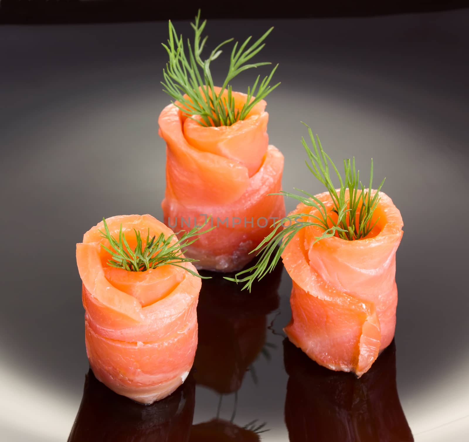 Salmon rolls on black plate