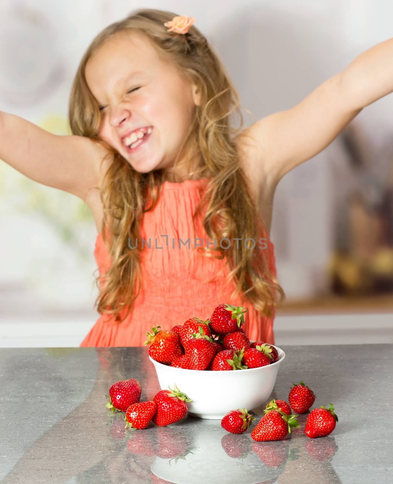 Little girl with strawberry at the table